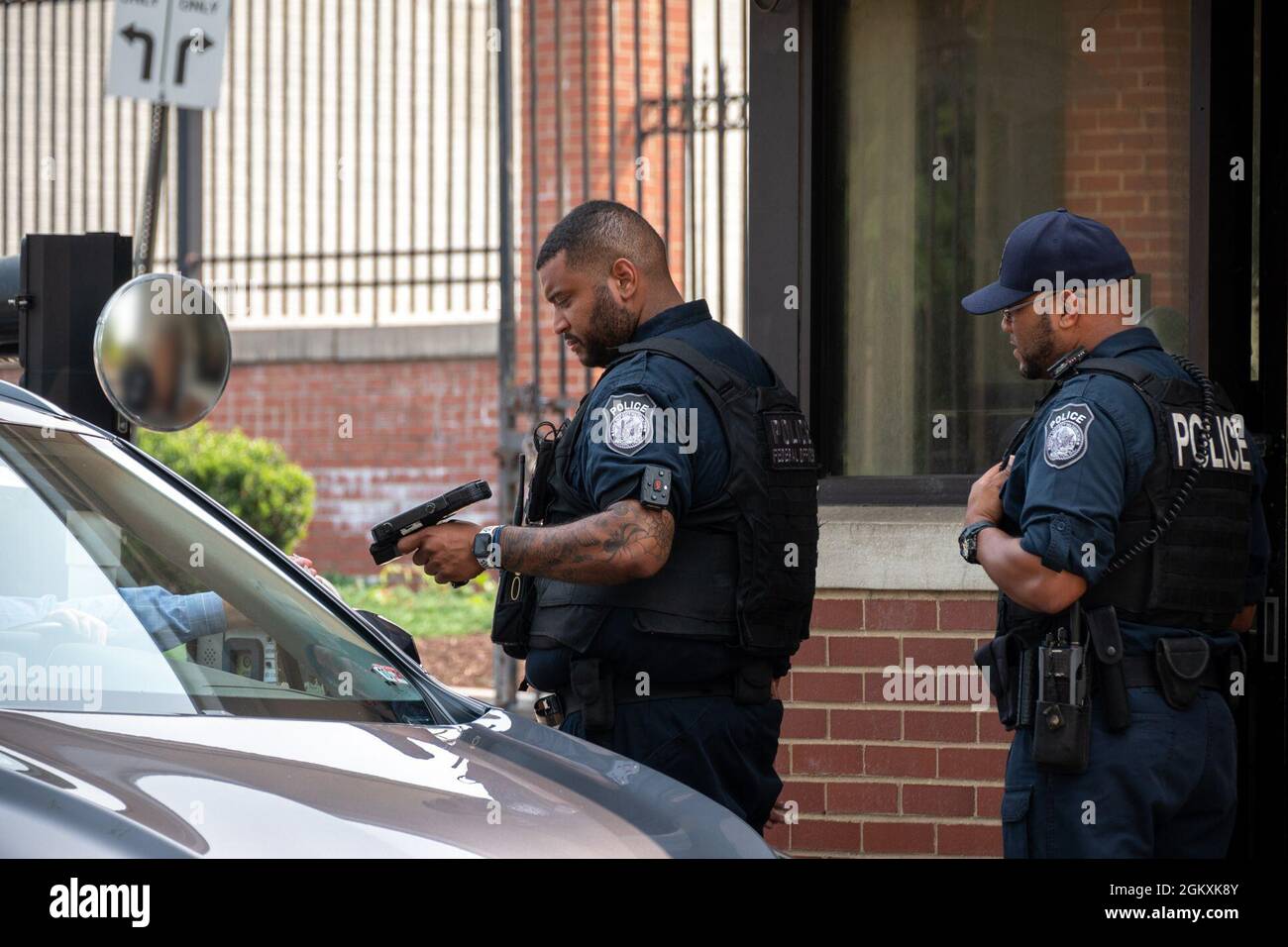 WASHINGTON, DC (July 20, 2021) – A Naval Support Activity Washington federal police officer scans an identification card prior to granting the driver access to Washington Navy Yard. Stock Photo