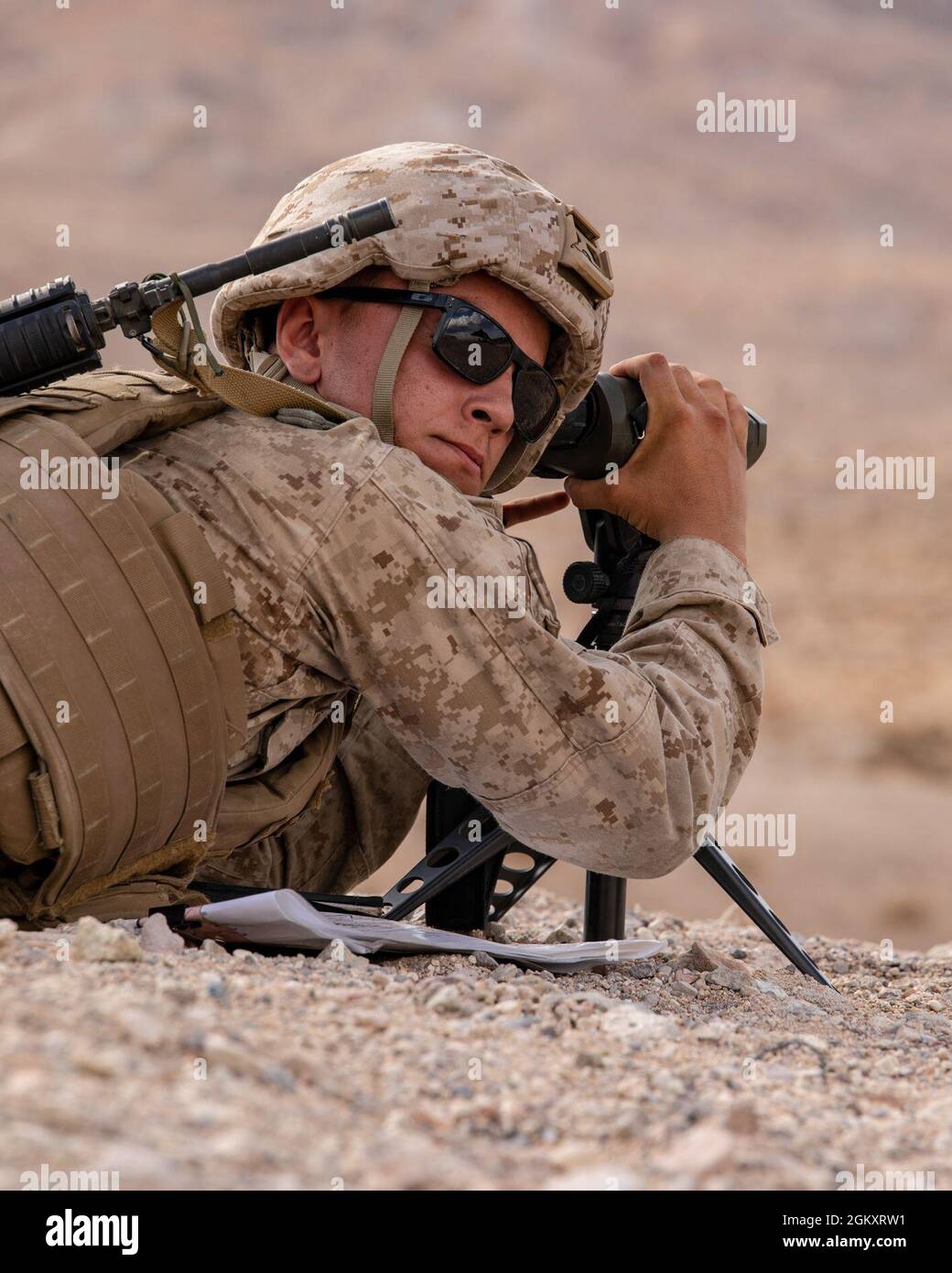 Lance Cpl. Reece Ackerman, a forward air observer with 3rd Battalion, 25th Marines observes targets during Fire Support Coordination Exercise (FSCEX) 1, a sub-event of Integrated Training Exercise (ITX) 4-21 at Marine Corps Air Ground Combat Center, Twentynine Palms, California on July 22, 2021. FSCEX allows Reserve Marines to coordinate various fires assets from across Marine Air Ground Task Force 25 to eliminate enemy positions in a simulated combat environment. Stock Photo