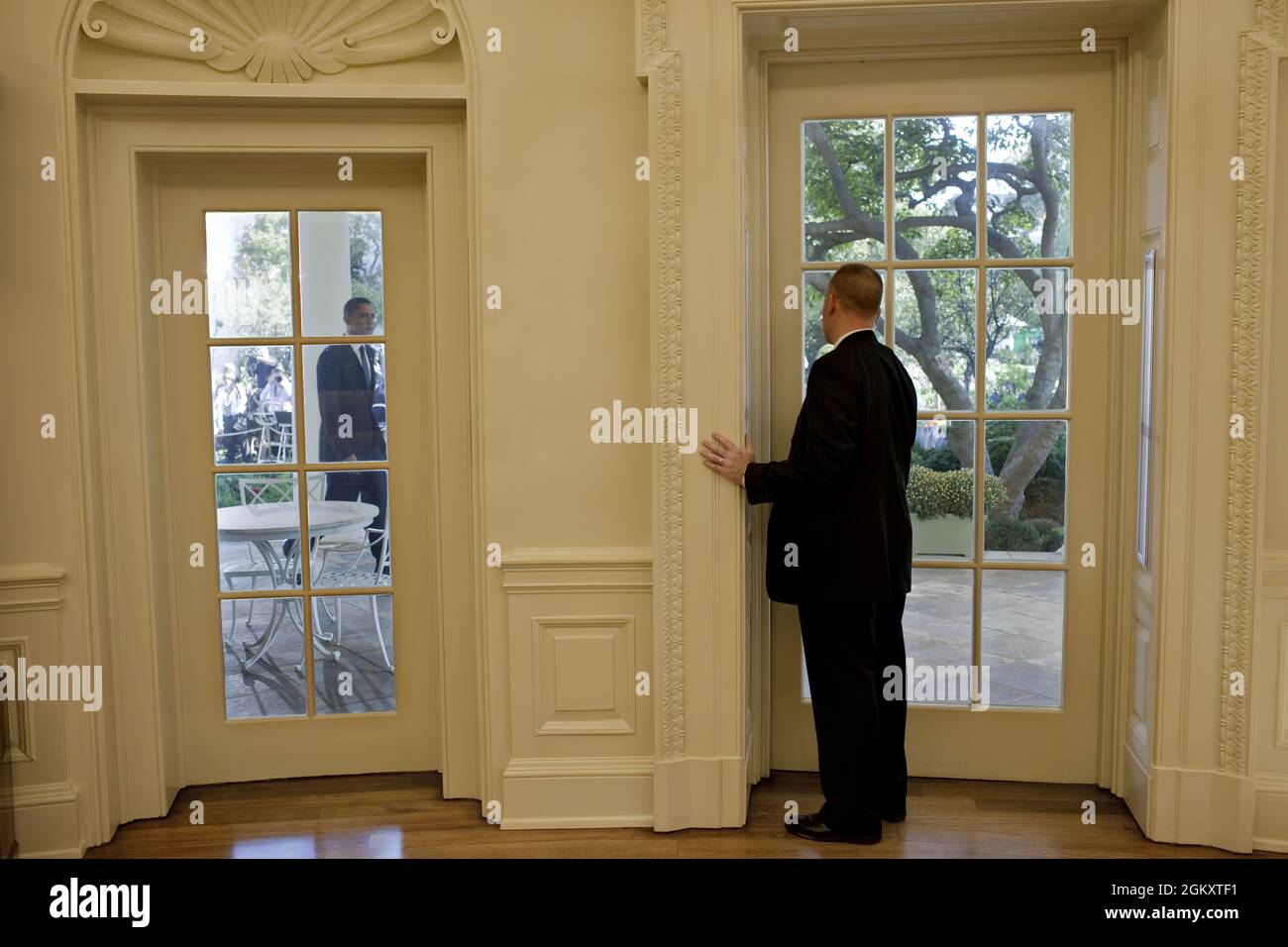 A staff member prepares to open the door to the Oval Office for President Barack Obama following his statement on winning the 2009 Nobel Peace Prize in the Rose Garden of the White House, Oct. 9, 2009.  (Official White House Photo by Pete Souza) This official White House photograph is being made available only for publication by news organizations and/or for personal use printing by the subject(s) of the photograph. The photograph may not be manipulated in any way and may not be used in commercial or political materials, advertisements, emails, products, promotions that in any way suggests app Stock Photo