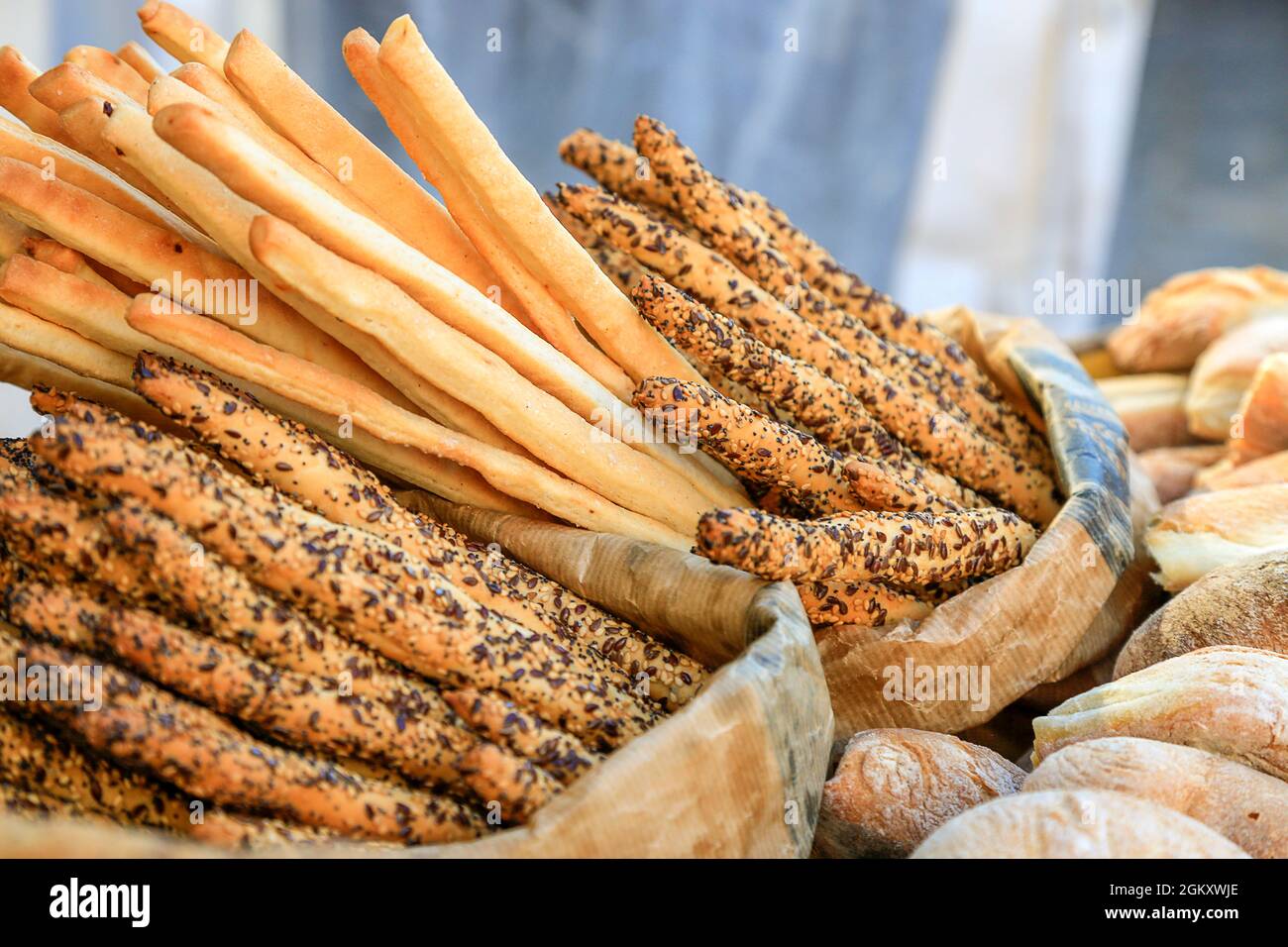 many fresh bread sticks with salt and seeds in paper bags and other bakery  around. degustation of bread. Catering and finger food. Wallpaper and Stock  Photo - Alamy