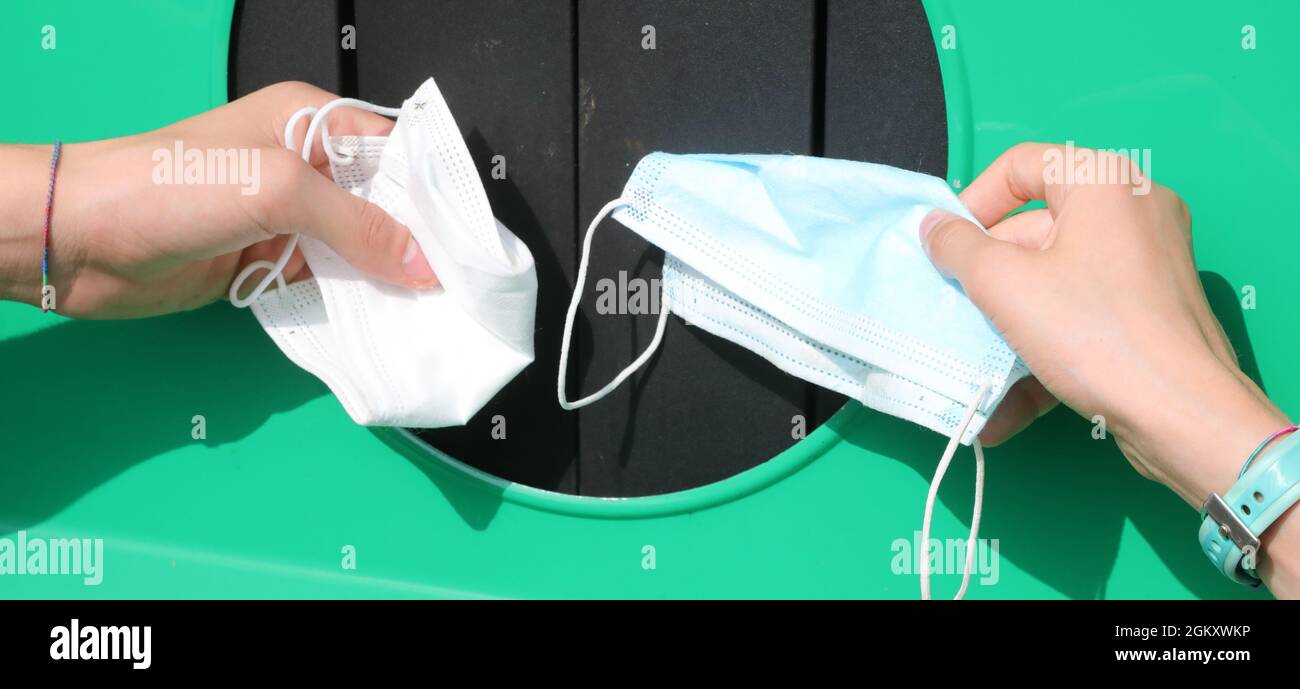 boy and girl throw their used surgical masks in the recycling bin to avoid environmental pollution Stock Photo