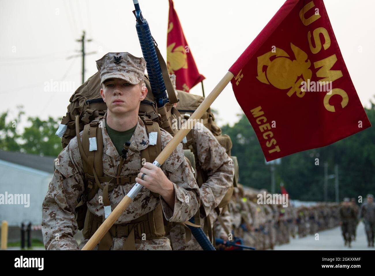 U.S. Navy Religious Program Specialist 3rd Class Tristan Q. A. Hawkins, a student with Field Medical Training Battalion-East (FMTB-E), Training Command, holds the company guidon during a two-mile hike on Camp Johnson, N.C., July 22, 2021. Students of FMTB-E participate in four different hikes during a normal training evolution to better prepare themselves for the physical rigors of being attached to their future U.S. Marine Corps units. Stock Photo