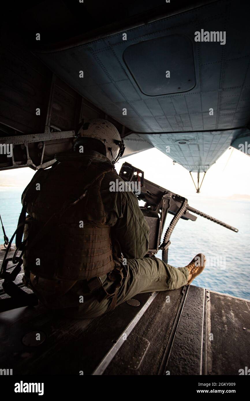 U.S. Marine Corps Sgt. Cody Mangel, a crew chief with Marine Heavy Helicopter Squadron 463, mans a mounted machine gun on the back of a CH-53 Super Stallion attached to HMH-463 during an insertion and extraction training event with U.S. Marines from 1st Battalion, 3d Marines, Marine Corps Base Hawaii, July 22, 2021. As a host platform to all elements of the Marine Air Ground Task Force, Marine Corps Base Hawaii provides the necessary environment to produce readiness in the air, on land and at sea. Stock Photo