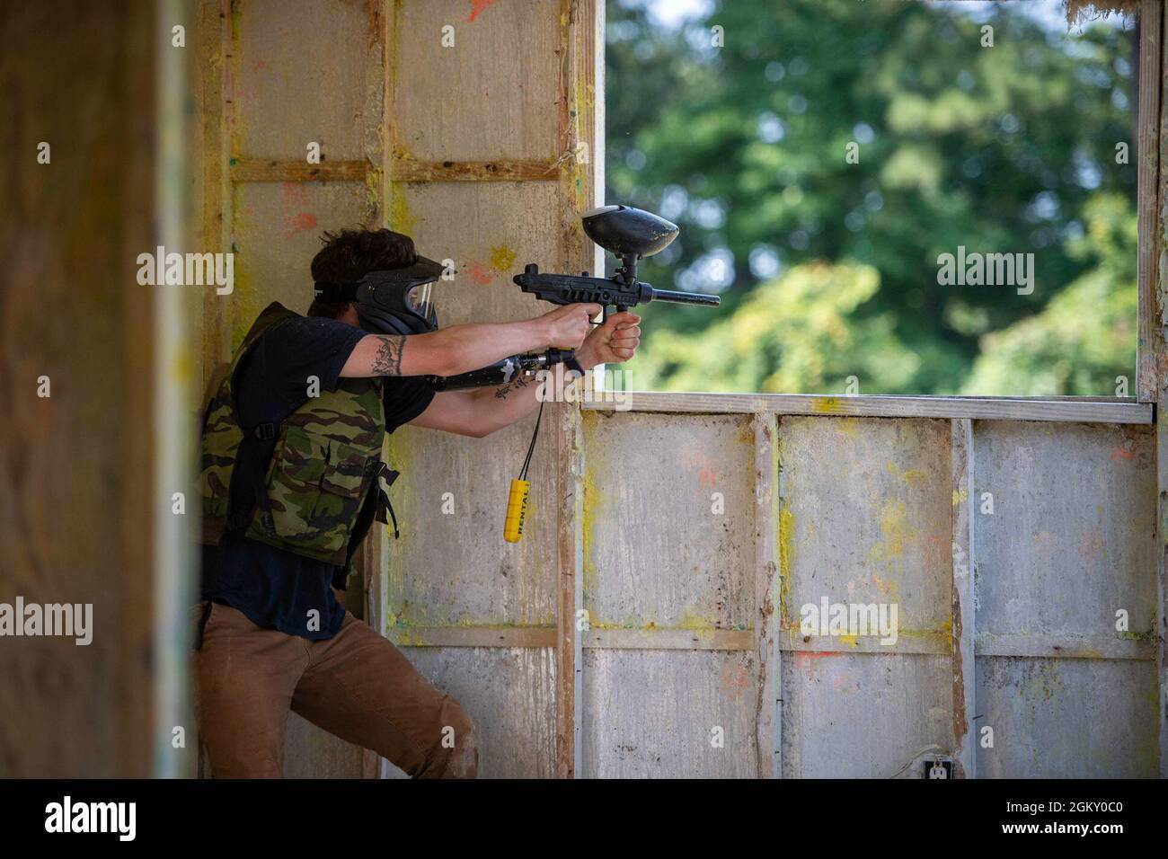 U.S. Navy Logistics Specialist 3rd Class Bailey Stephenson, from Longmont, Colorado, assigned to the aircraft carrier USS John C. Stennis (CVN 74), fires a paintball marker through the window on a paintball field during a Morale, Welfare, and Recreation event, in Hampton, Virginia, July 22, 2021. John C. Stennis is in Newport News Shipyard working alongside NNS, NAVSEA and contractors conducting Refueling and Complex Overhaul as part of the mission to deliver the warship back in the fight, on time and on budget, to resume its duty of defending the United States. Stock Photo