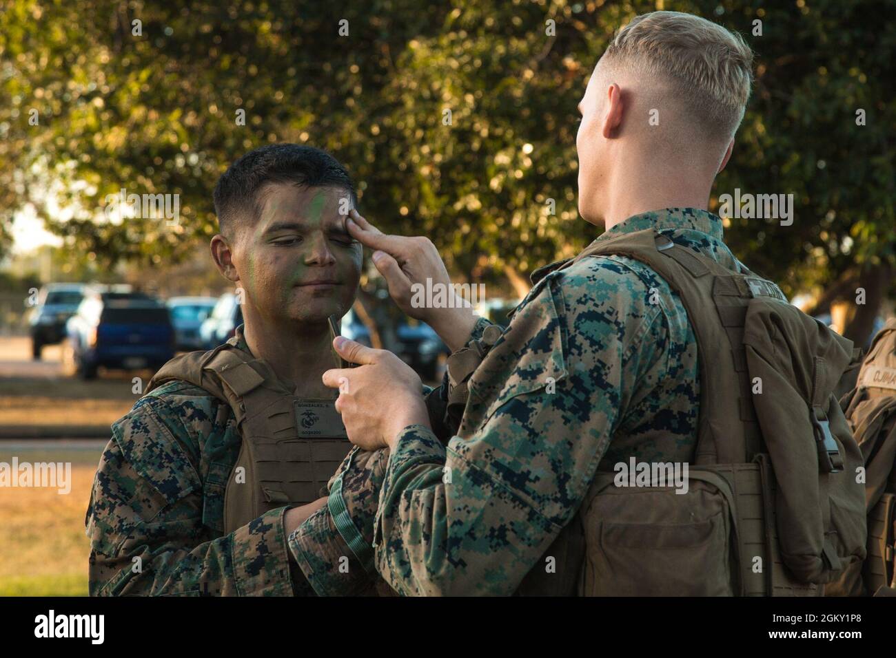 U.S. Marines with Charley Company, 1st Battalion, 7th Marine Regiment, Marine Rotational Force Darwin 21.2, aid each other in applying camouflage paint prior to Operation Sea Raider during Talisman Sabre 2021 in Townsville, Queensland, Australia, July 23, 2021. TS21 supports the U.S. National Defense Strategy by enhancing the ability to protect the homeland and provide combat-credible forces to address the full range of potential security concerns in the Indo-Pacific.ts that reinforce the strong U.S./Australian alliance and demonstrate the U.S. Military’s unwavering commitment to a free and op Stock Photo
