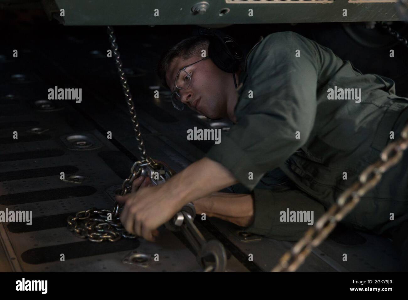 U.S. Marine Corps Sgt. Matthew Beyersdorf, a loadmaster with Marine Aerial Refueler Transport Squadron (VMGR) 152, chains down a High Mobility Artillery Rocket System vehicle in a KC-130J Super Hercules with VMGR-152 in support of Exercise Talisman Sabre 21 from Whitsunday Coast Airport, Queensland, Australia, July 25, 2021. Australian and U.S. Forces combine biannually for Talisman Sabre, a month-long multi-domain exercise that strengthens allied and partner capabilities to respond to the full range of Indo-Pacific security concerns. Stock Photo