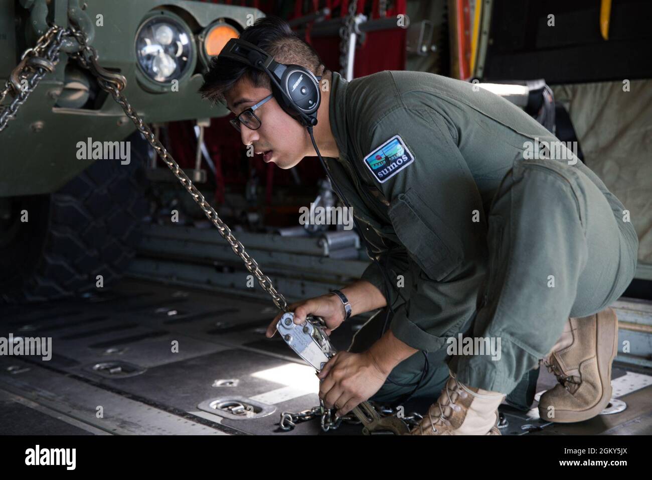 U.S. Marine Corps Sgt. John Madrigal, a loadmaster with Marine Aerial Refueler Transport Squadron (VMGR) 152, chains down a High Mobility Artillery Rocket System vehicle in a KC-130J Super Hercules with VMGR-152 in support of Exercise Talisman Sabre 21 from Whitsunday Coast Airport, Queensland, Australia, July 25, 2021. Australian and U.S. Forces combine biannually for Talisman Sabre, a month-long multi-domain exercise that strengthens allied and partner capabilities to respond to the full range of Indo-Pacific security concerns. Stock Photo