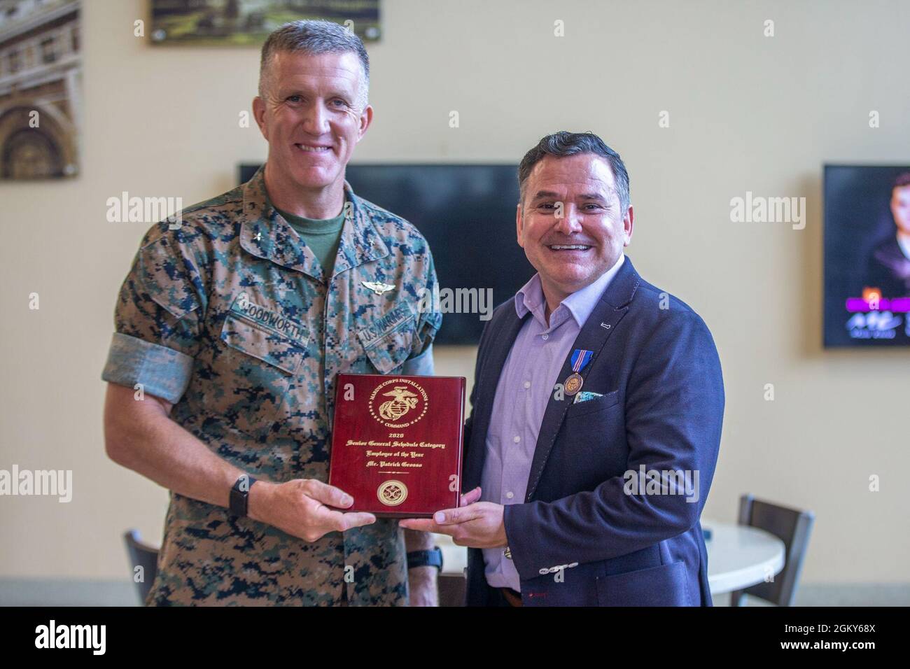 U.S. Marine Brig. Gen. Jason Woodworth, the commanding general for Marine Corps Installations West, Marine Corps Base Camp Pendleton, poses with Patrick Grosso, the food service director for G-4 Logistics, MCI-West, after presenting him the Commendation for Meritorious Civilian Service Award and the Marine Corps Installations Command Senior General Schedule Employee of the Year Award, at the 22 Area Mess Hall on Camp Pendleton California, July 26, 2021. Grosso was awarded the employee of the year award in response to his leadership and professionalism during the COVID-19 pandemic. Stock Photo