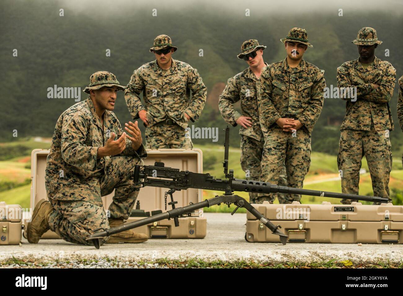 U.S. Marine Corps Cpl. Idan Urrutiagarces, a section leader with Fox Company, 2nd Battalion, 2nd Marines, 3d Marine Division, teaches Marines how to operate an M2 .50-caliber machine gun before conducting a machine gun course of fire on Range 10, Camp Schwab, Okinawa, Japan, July 26, 2021. Marines with 3d Landing Support Battalion, Combat Logistics Regiment 3, 3d Marine Logistics Group, assisted by Marines with 2/2, conducted a range to maintain proficiency while utilizing mounted M2 .50-caliber and M240B medium machine guns. 3d MLG, based out of Okinawa, Japan, is a forward deployed combat un Stock Photo