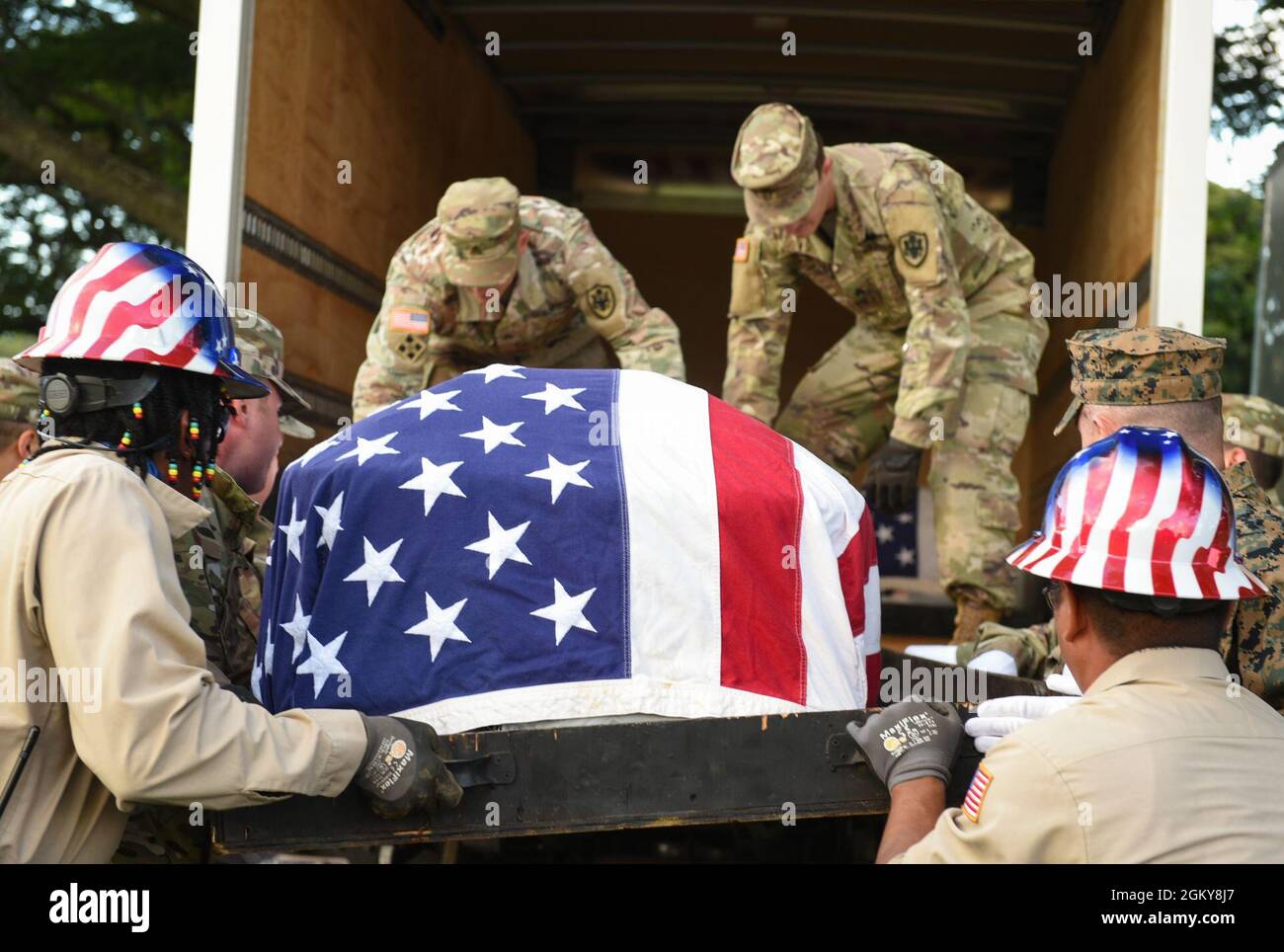 Members of the Defense POW/MIA Accounting Agency (DPAA), helped by members of the National Memorial Cemetery of the Pacific disinterment team, lift a casket during a disinterment ceremony at the NMCP (Punchbowl) in Honolulu, Hawaii, July 26, 2021. The ceremony was part of the agency’s efforts to disinter and identify the remains of unknown service members lost during the Korean War. DPAA’s mission is to achieve the fullest possible accounting for missing and unaccounted-for U.S. personnel to their families and our nation Stock Photo