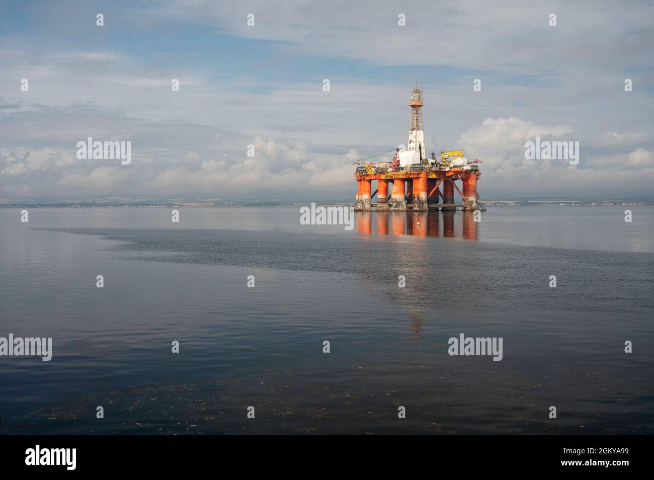Floating orange and white oil rig in the Cromarty Firth. Sunny day with blue sky and clouds, no people. Lots of copy space. Stock Photo
