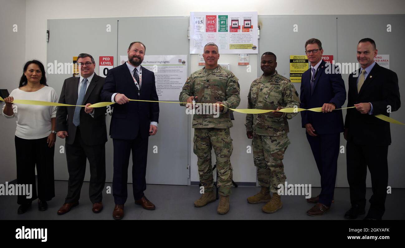 Members from the Program Executive Office Enterprise Information Systems, 2d Theater Signal Brigade and the 102d Strategic Signal Battalion prepare to cut the ribbon to celebrate the opening of the new migrated Technical Control Facility Landstuhl. The TCF Landstuhl, which falls under the operational control of the 2d Theater Signal Brigade, serves as a major communications capability for the joint and combined forces in the area, and serves as a major communications hub for forces in EUCOM, AFRICOM, and CENTCOM. Stock Photo
