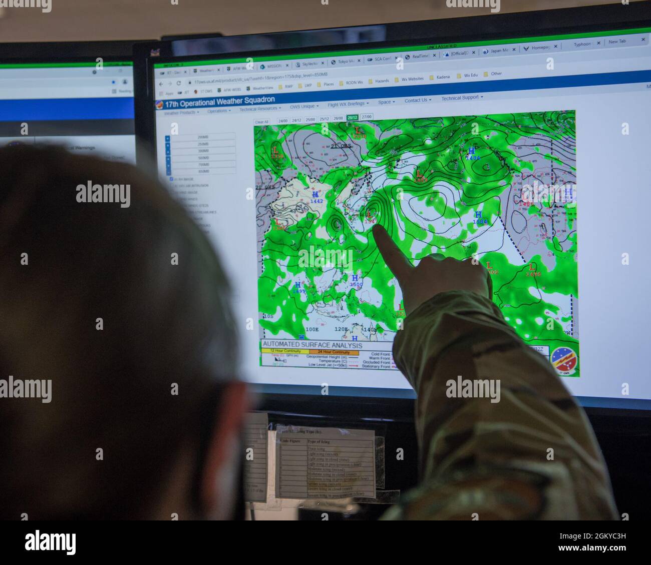 U.S. Air Force Tech. Sgt. Cassandra Lane, 18th Operations Support Squadron weather craftsman examines weather data for a tropical storm at Kadena Air Base, Japan, July 27, 2021. Weather models are becoming more accurate as technology advances, but weather predictions still require human analysis to be reliable. Forecasters often confirm the weather model matches the conditions outside through manual observation and they use their training on the dynamics of atmospheric conditions to verify the data is accurate. Stock Photo