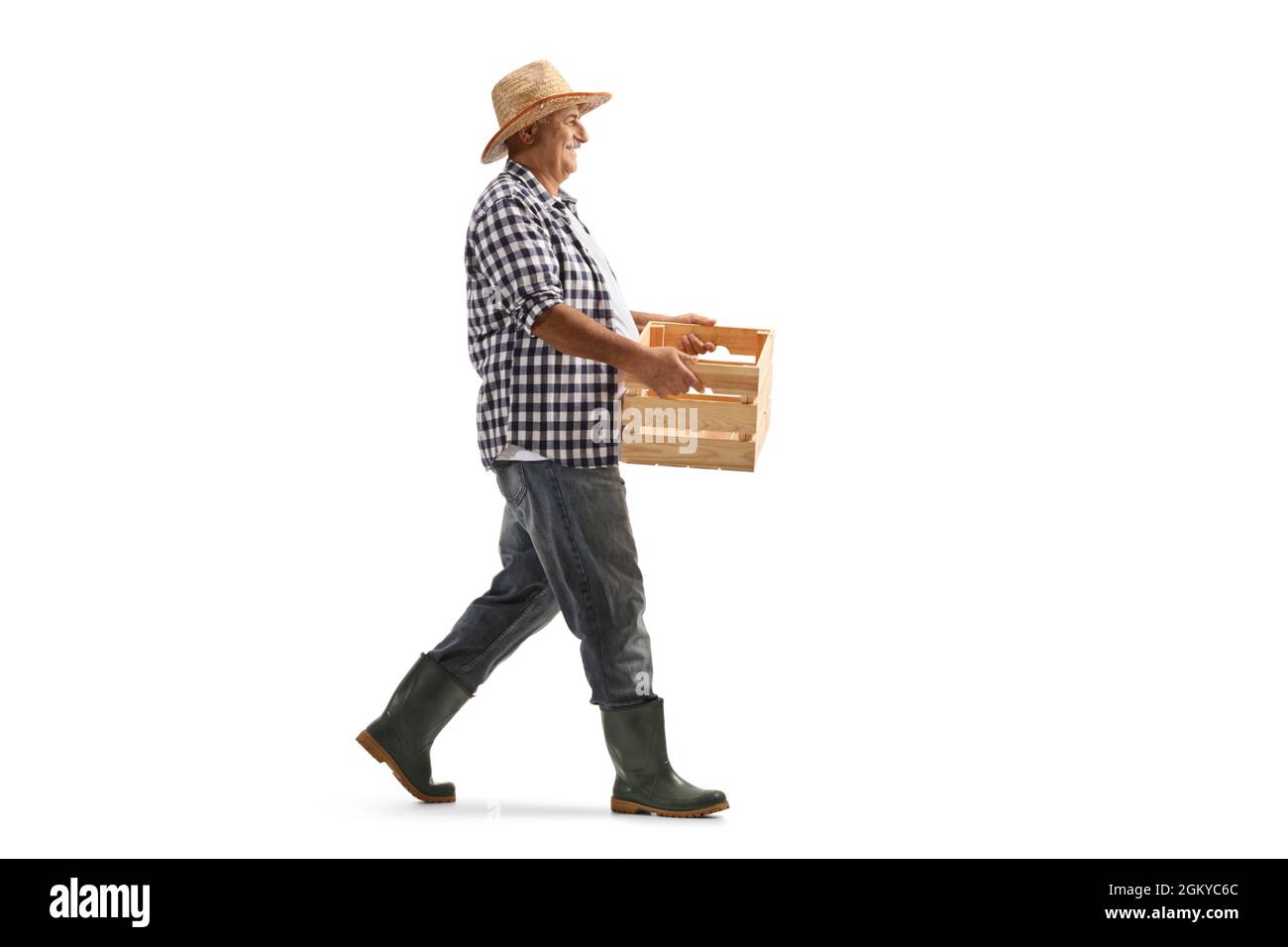 Full length profile shot of a mature farmer carrying a crate and ...