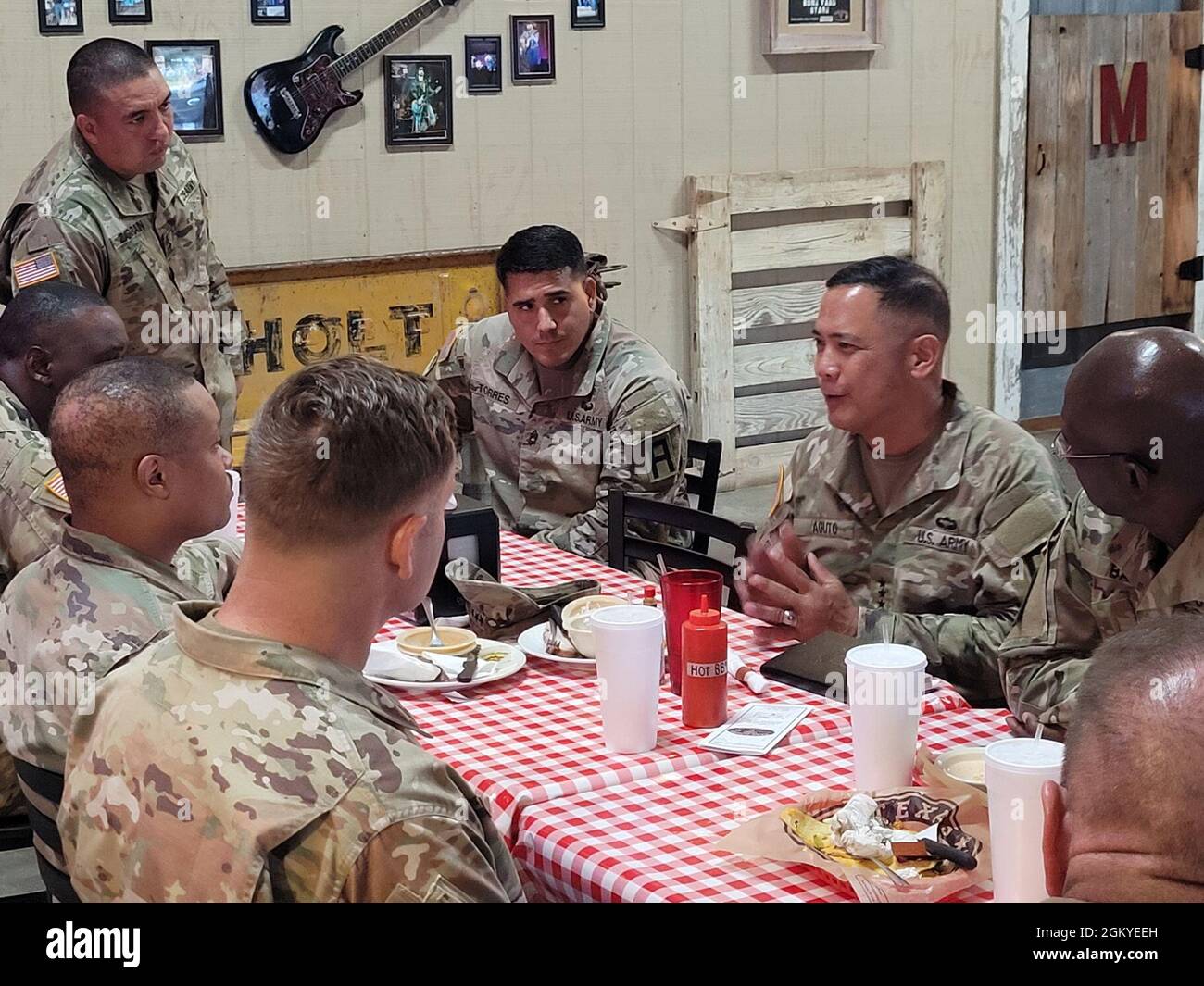 Lt. Gen. Antonio A. Aguto, commanding general of First Army (right), meets with OC/Ts from 120th Infantry Brigade and 166th Aviation Brigade over a lunch at Barebones BBQ restaurant in Gatesville, Texas on July 28, 2021. Topics discussed included the commanding general's interest in the daily work of the OC/Ts, Soldier welfare, and shared Army training stories. Stock Photo