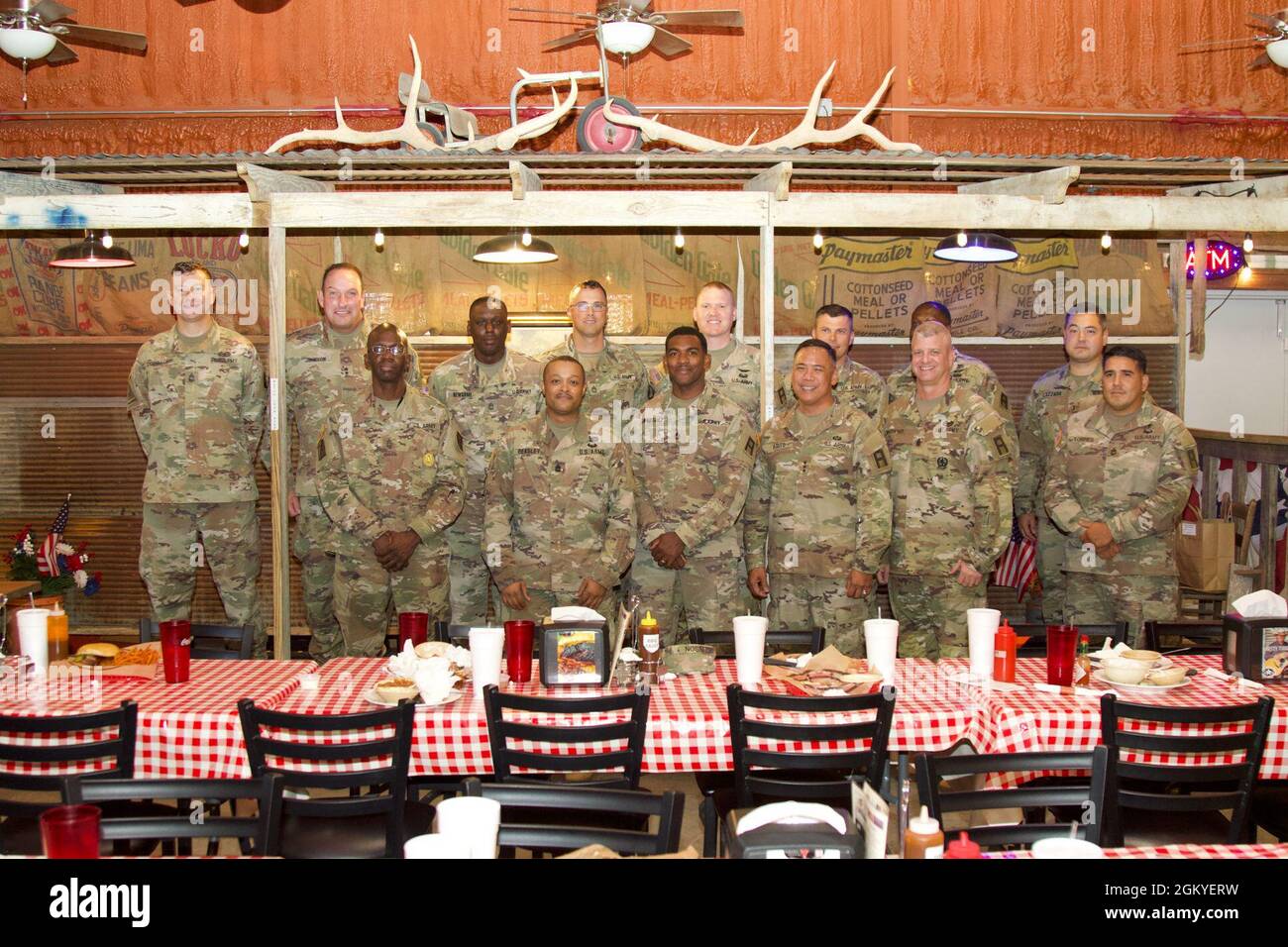 Lt. Gen. Antonio A. Aguto, commanding general of First Army (front row, third from right), and Command Sgt. Maj. John P. McDwyer, command sergeant major of First Army (front row, second from right), join with Division West OC/T Soldiers of 120th Infantry Brigade and 166th Aviation Brigade, during a lunch break at the Barebones BBQ restaurant in Gatesville, Texas, July 28, 2021. Stock Photo