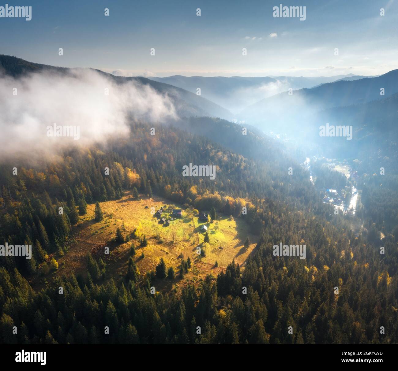 Aerial view of beautiful village in mountains in low clouds Stock Photo ...
