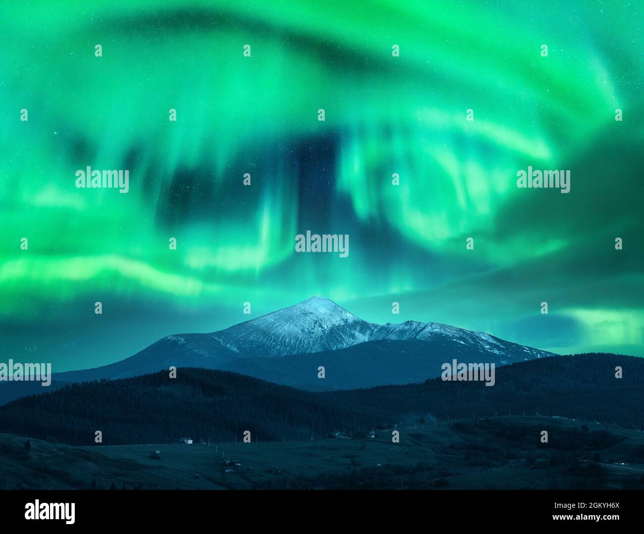 Aurora borealis over the snow covered mountain peak in europe Stock Photo