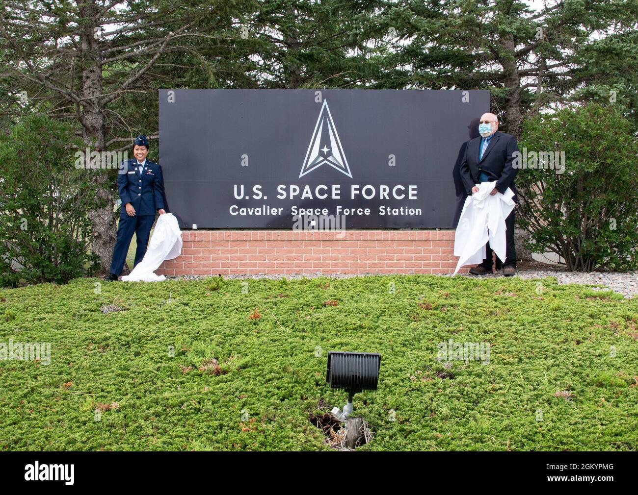 2nd Lt. Kathryn Odom, left, 10th Space Warning Squadron crew commander, and Ronald Belanus, 10 SWS system analyst, unveil the Cavalier Space Force Station sign during the renaming ceremony at Cavalier SFS, N.D., July 30, 2021. The sign was unveiled by the oldest and youngest members of the squadron in honor of Cavalier Air Force Station being renamed as a U.S. Space Force installation. Stock Photo