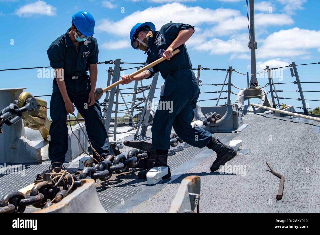 210730-N-LP924-1221 PACIFIC OCEAN (July 30, 2021) Boatswain’s Mate Seaman Dylan Brussman, right, a native of Surprise, Arizona, knocks free the anchor chain aboard Arleigh Burke-class destroyer USS Michael Murphy (DDG 112), July 30, 2021. Murphy is currently underway conducting routine operations in U.S. Third Fleet. Stock Photo