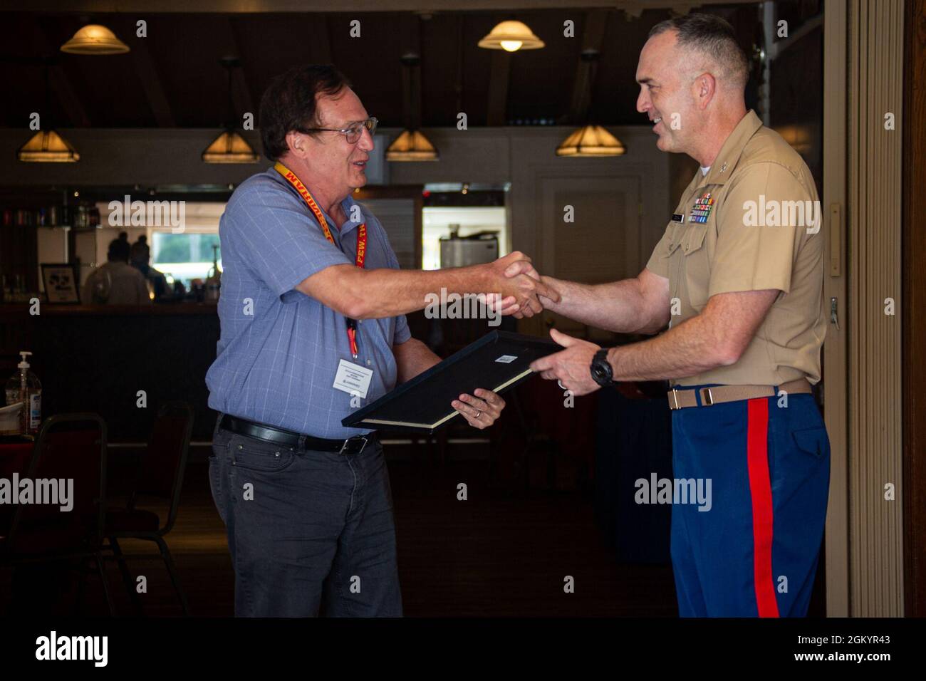 U.S. Marine Corps Col. James B. Conway, the commanding officer for the 12th Marine Corp District, awards Scott Phillips, a military entrance processing station liaison, native to El Segundo, California, during the Educator's Workshop at Marine Corps Recruit Depot San Diego, California, July 30, 2021. The Educator's Workshop is a five-day program designed to better inform educators and influential figures about the benefits and opportunities available during service in the Marine Corps. This allows participants to return home and provide firsthand experience and knowledge to individuals interes Stock Photo