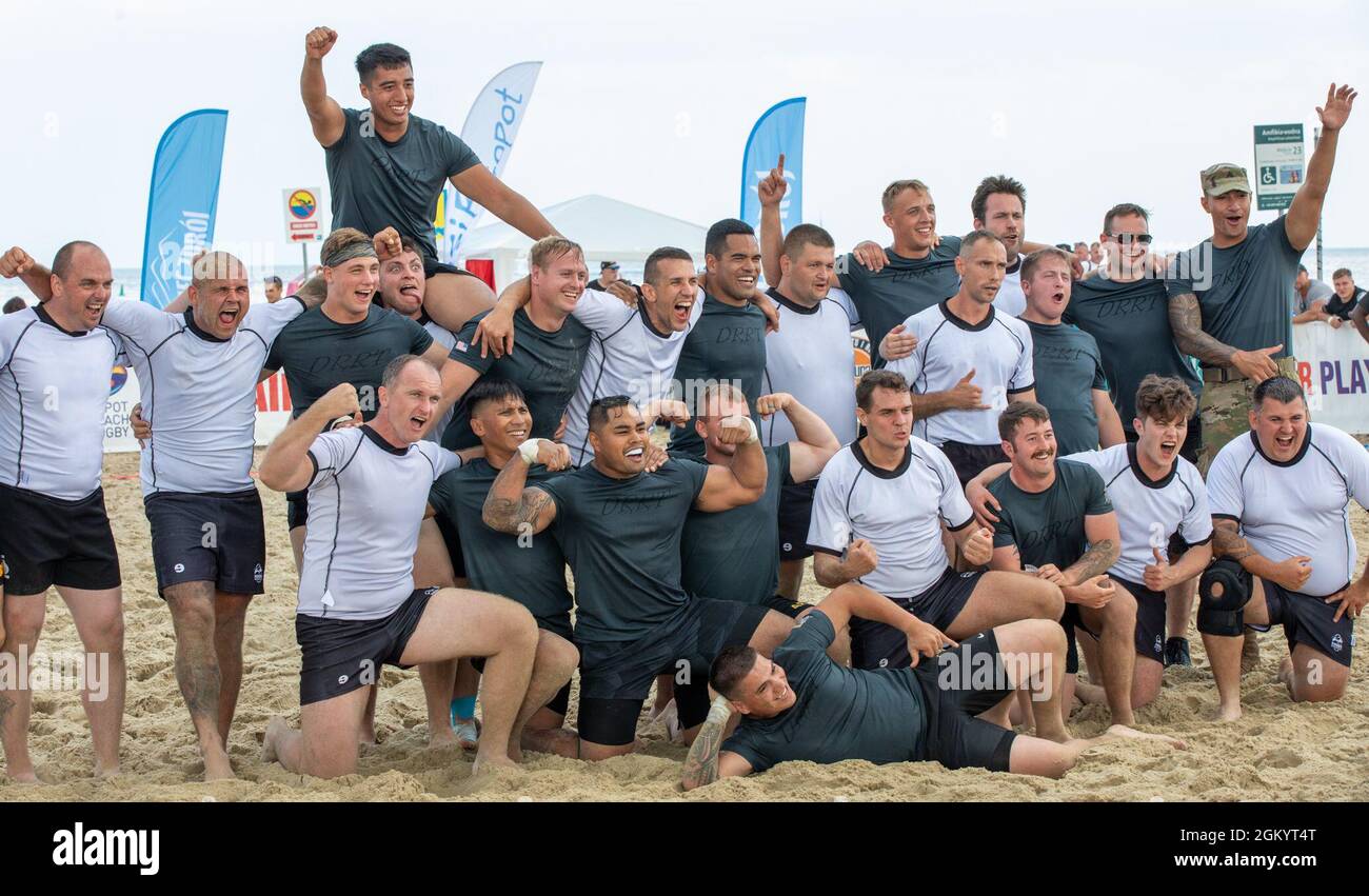 Soldiers with 3rd Battalion “Dark Rifles,” 161st Infantry Regiment (black uniforms) come together for a photo with an opposing rugby team at the Sopot International Beach Rugby Tournament in Sopot, Poland, July 31, 2021. The 3-161 is a Washington Army National Guard battalion on deployment as part of NATO’s Enhanced Forward Presence, Battle Group Poland to enhance international ties and increase interoperability. Stock Photo