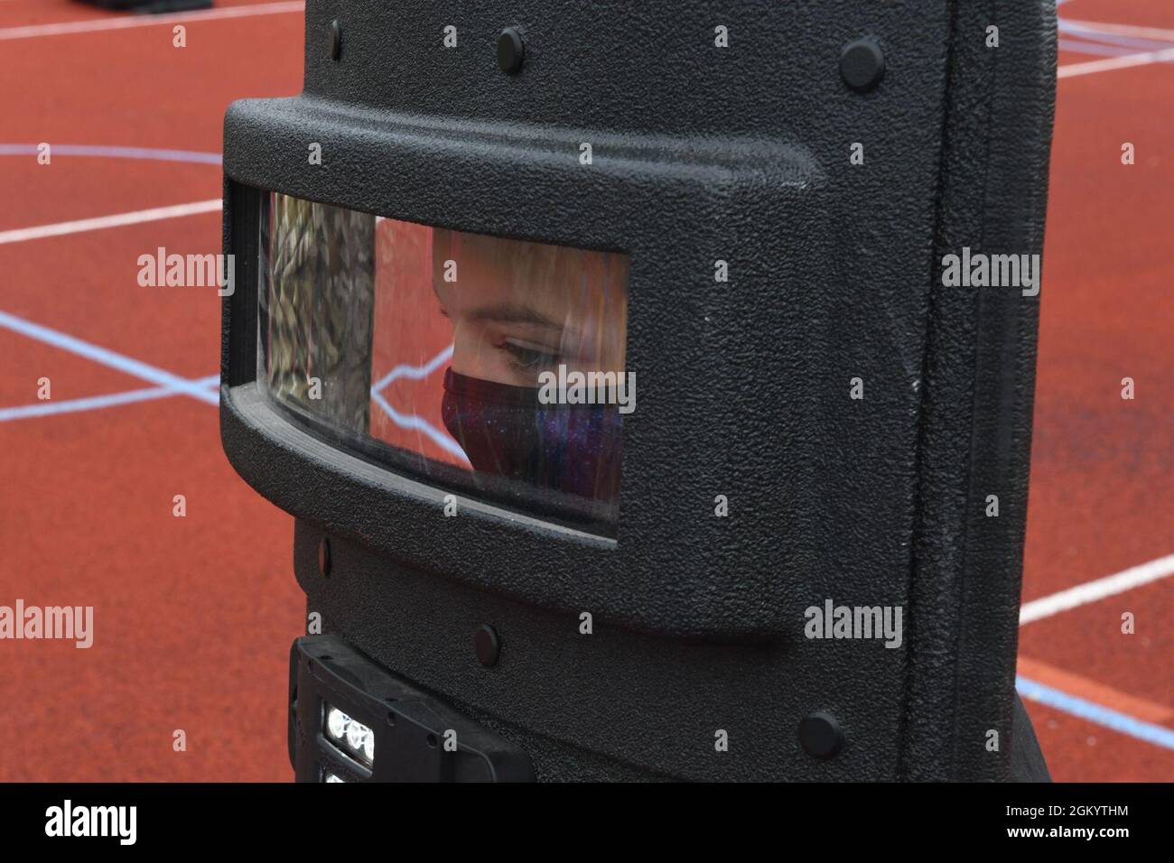 A child from the Royal Air Force Mildenhall Youth Center holds a police riot shield during the Junior Police Course at RAF Mildenhall, England, July 7, 2021. The Junior Police Course gave children the opportunity to see what Security Forces Airmen do and how they execute their mission safely. Stock Photo