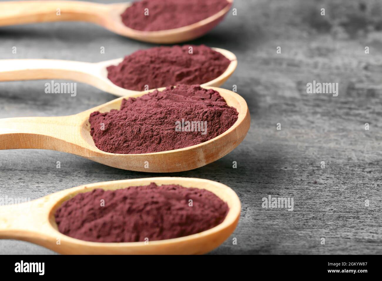 Wooden spoons with acai powder on grey background Stock Photo Alamy