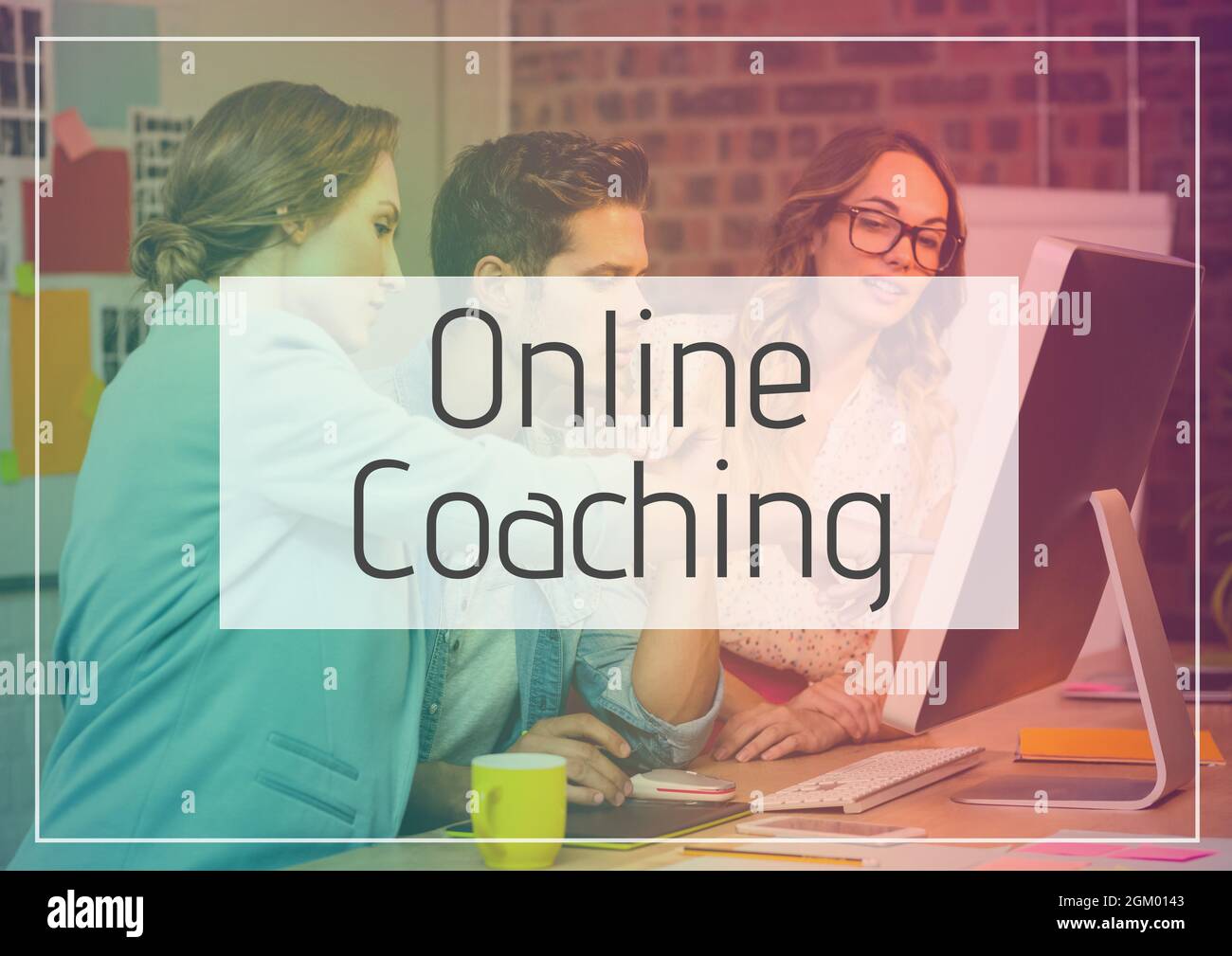 Online coaching text banner against office colleagues using computer at office Stock Photo