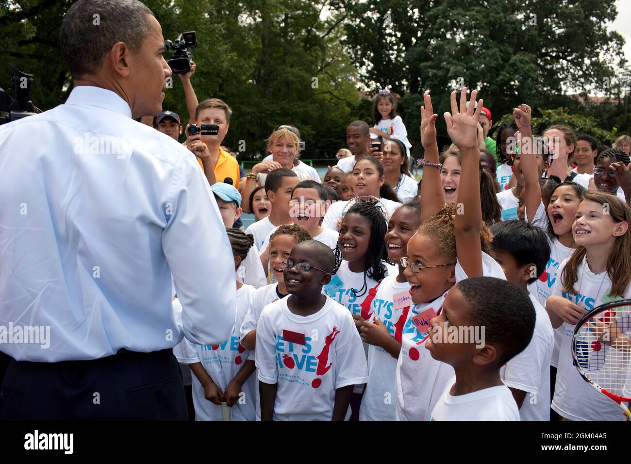President Barack Obama talks with kids attending a Let's Move! tennis clinic on the South Lawn of the White House, Aug. 3, 2010. (Official White House Photo by Pete Souza)This official White House photograph is being made available only for publication by news organizations and/or for personal use printing by the subject(s) of the photograph. The photograph may not be manipulated in any way and may not be used in commercial or political materials, advertisements, emails, products, promotions that in any way suggests approval or endorsement of the President, the First Family, or the White House Stock Photo