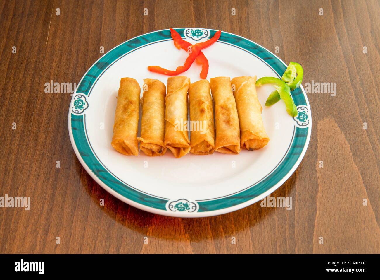 Chinese imperial crunchy rolls fried in olive oil on white plate Stock Photo