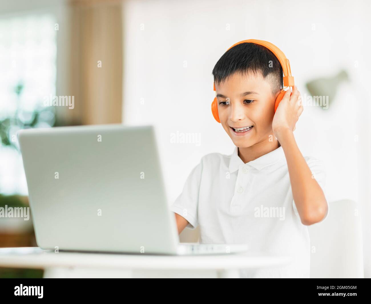 Boy wearing headphones and studying online with laptop Stock Photo - Alamy