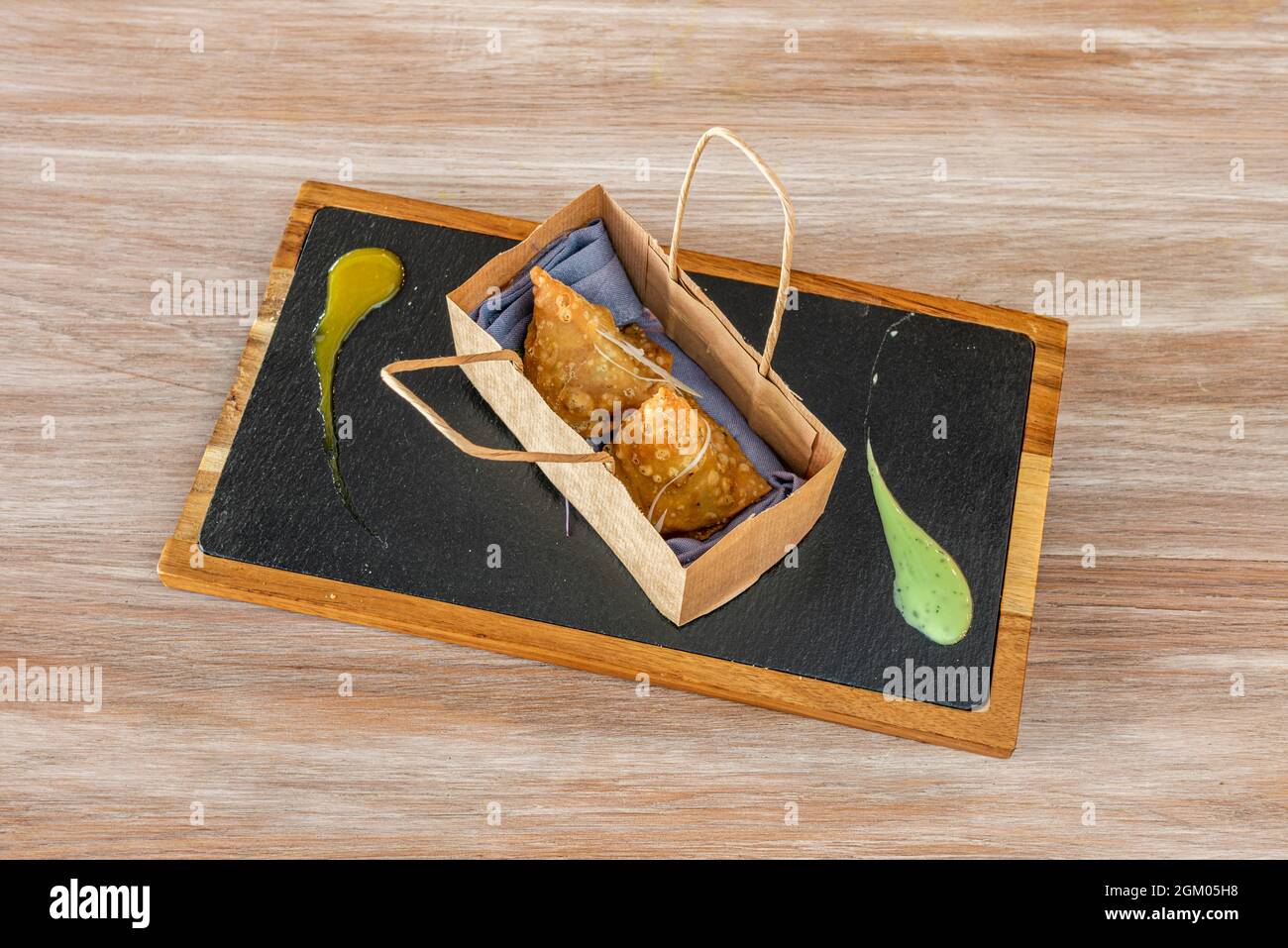 Samosas in recycled paper trompe l'oeil bag for home delivery Stock Photo