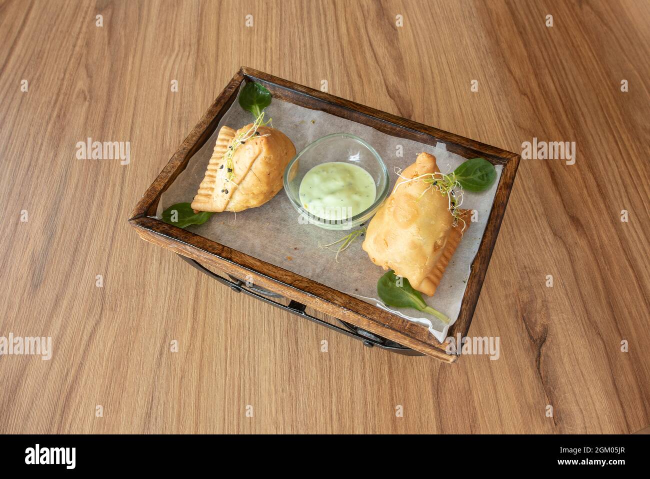 Fried samosas stuffed with vegetables with bean sprouts on top and Indian green sauce for dipping Stock Photo