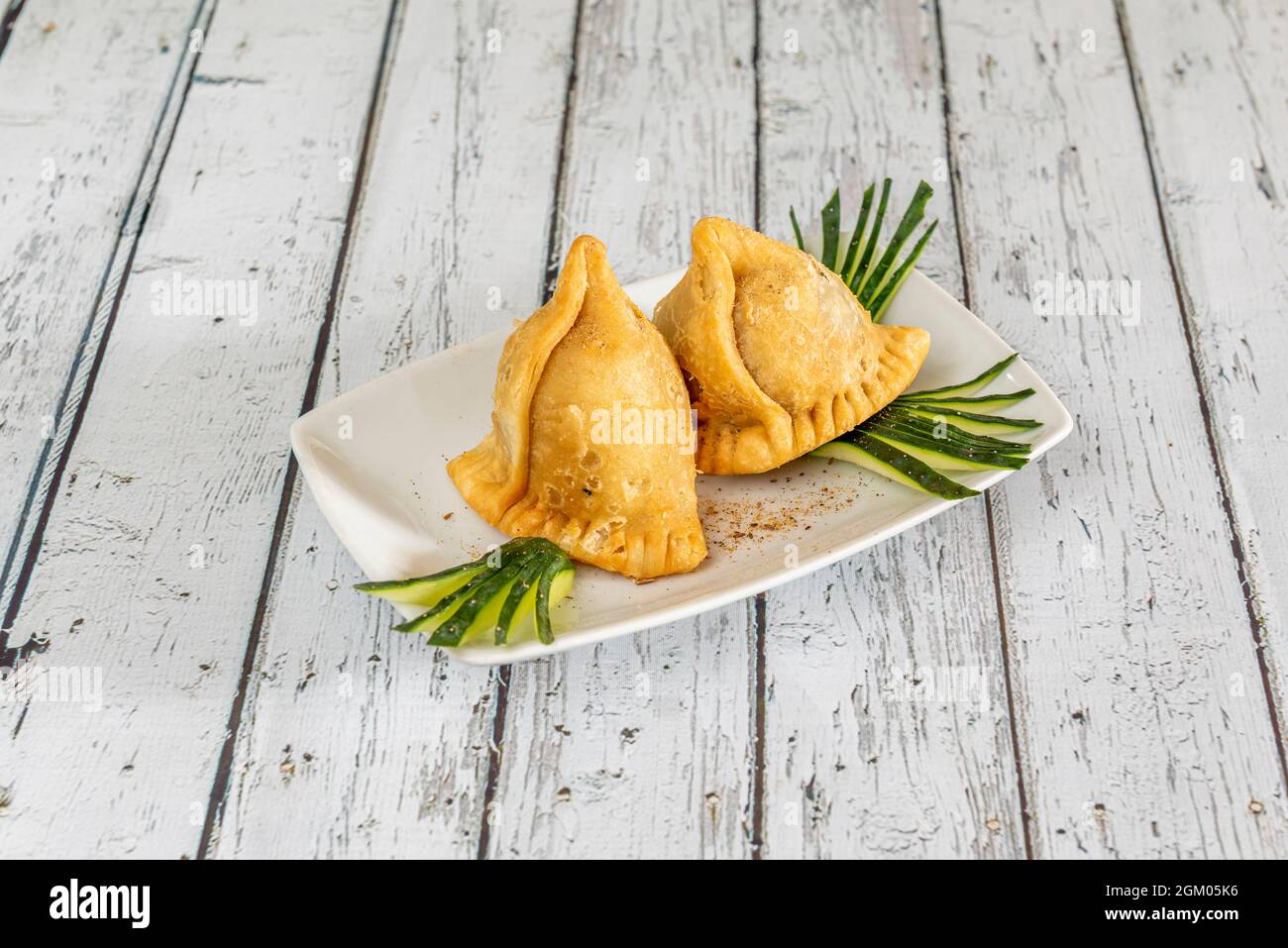 Portion of samosas stuffed with vegetables served in a pakistani restaurant in europe on a white table Stock Photo
