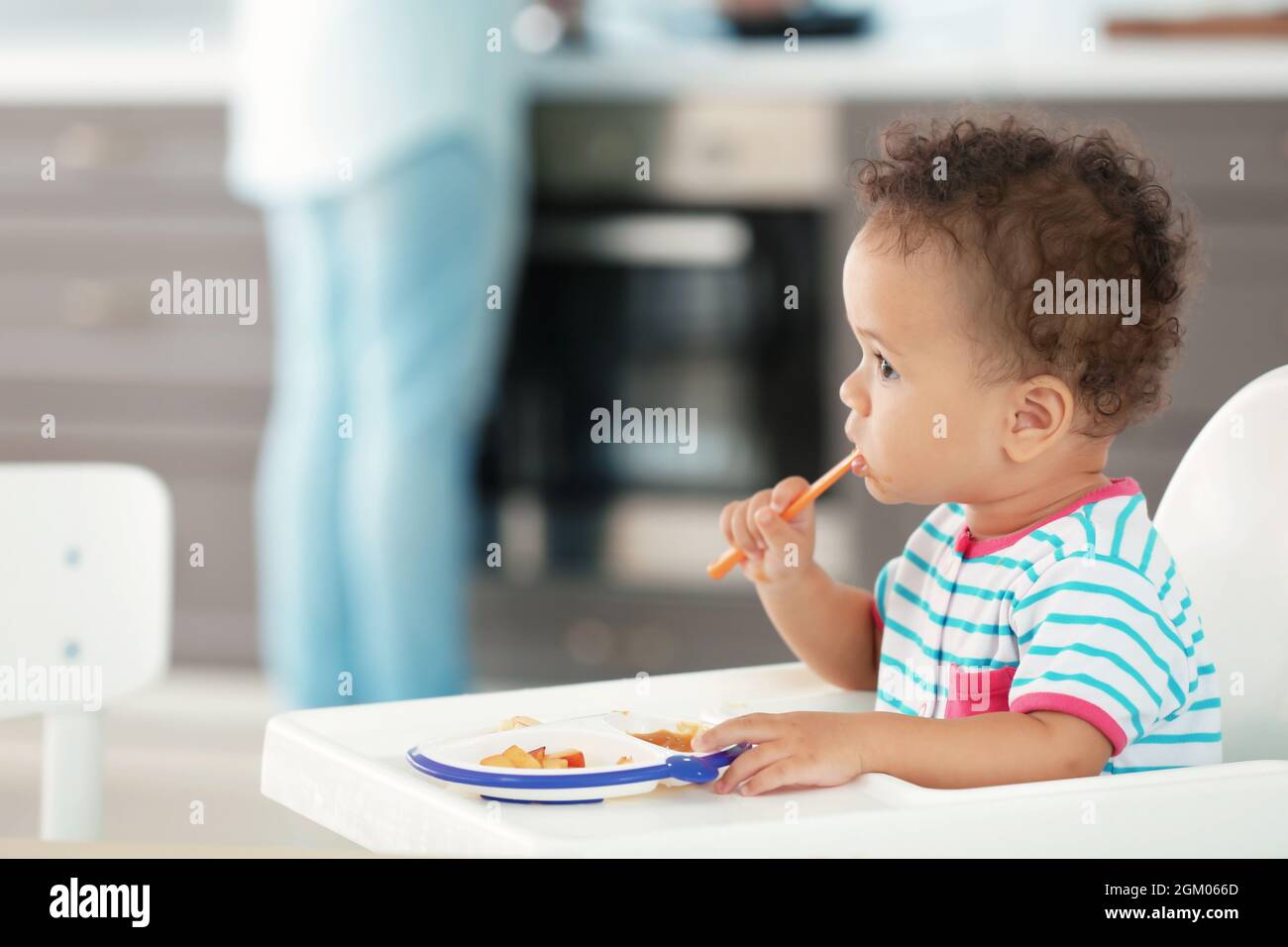 Little baby eating puree indoors Stock Photo - Alamy