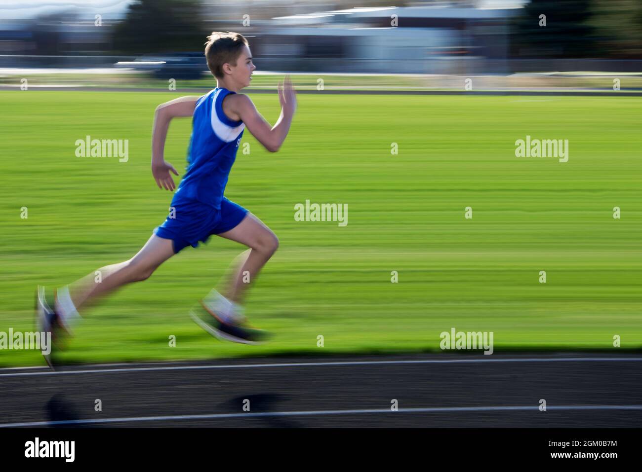 Boy running at track meet Stock Photo
