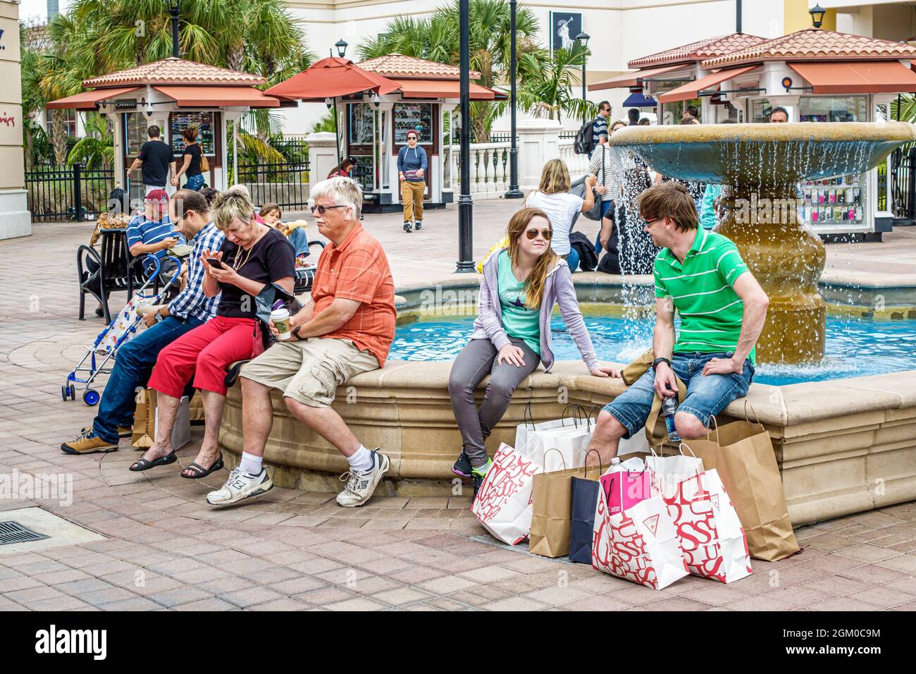 Orlando Florida,Orlando Premium Outlets International Drive,shopping shoppers shops stores,fountain bags teen teens teenagers girls resting family Stock Photo