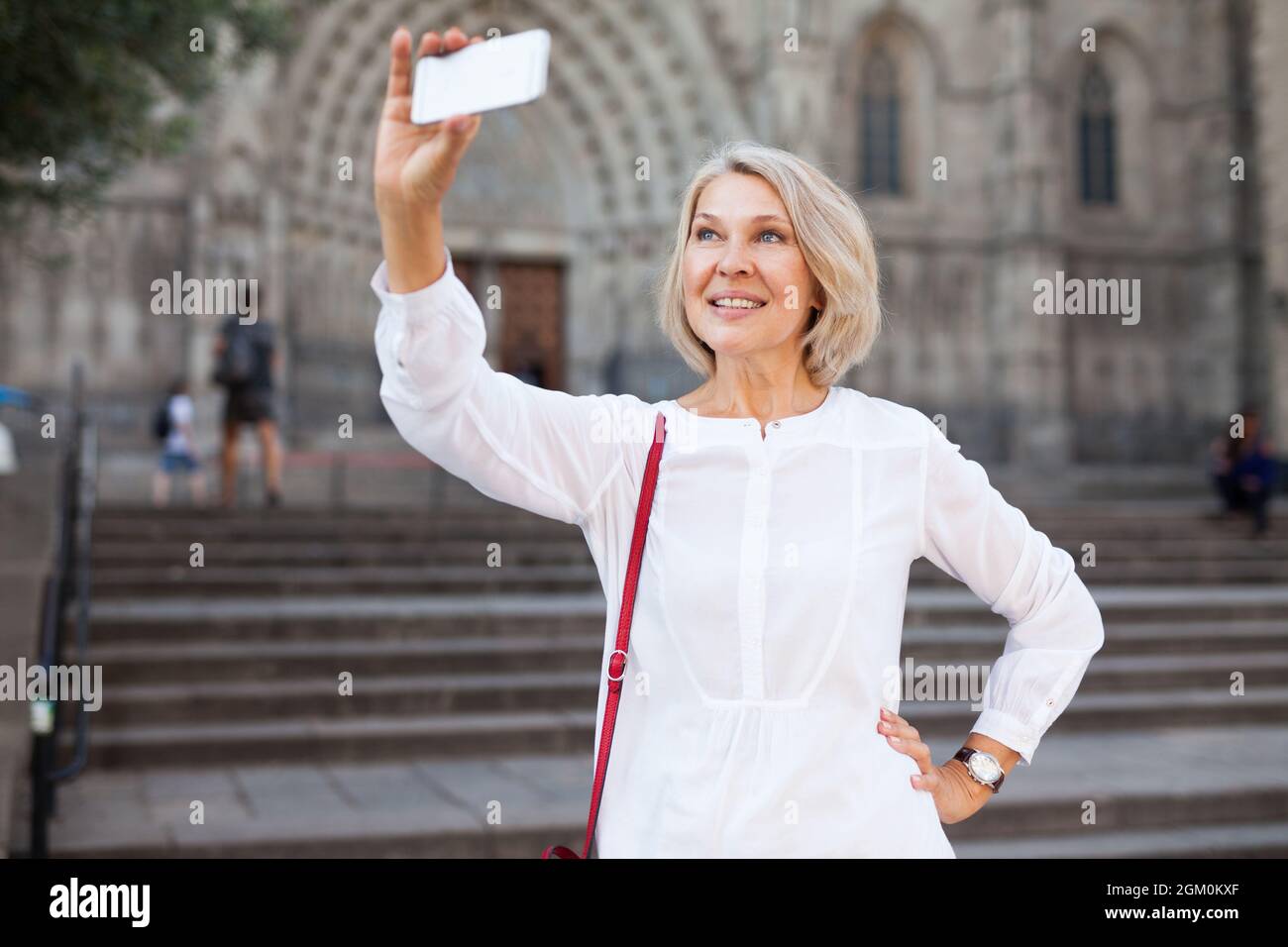 Mature female tourist making selfie on the background of landmark Stock Photo