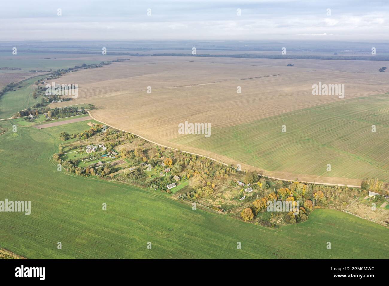 countryside view with village among cultivated fields at foggy morning. panoramic drone photo. Stock Photo