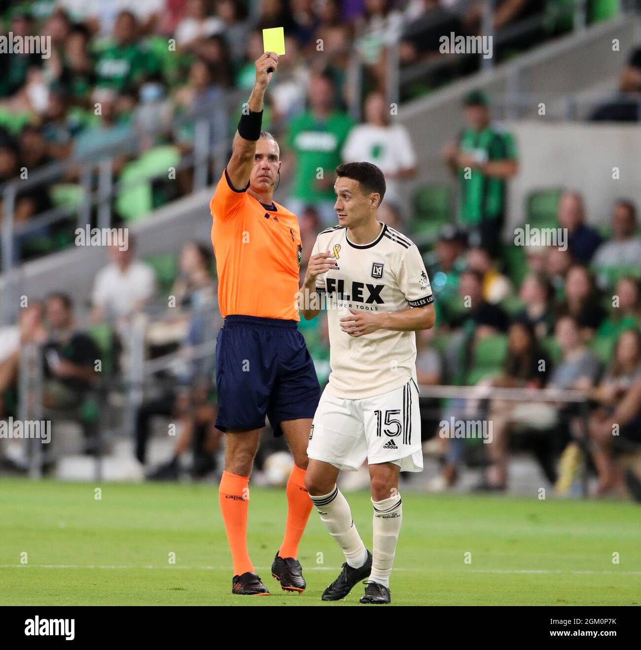 Austin, Texas, USA. September 15, 2021: Referee Tim Ford issues a yellow  card to Los Angeles FC midfielder Daniel Crisostomo (15) during a Major  League Soccer match between Austin FC and LAFC