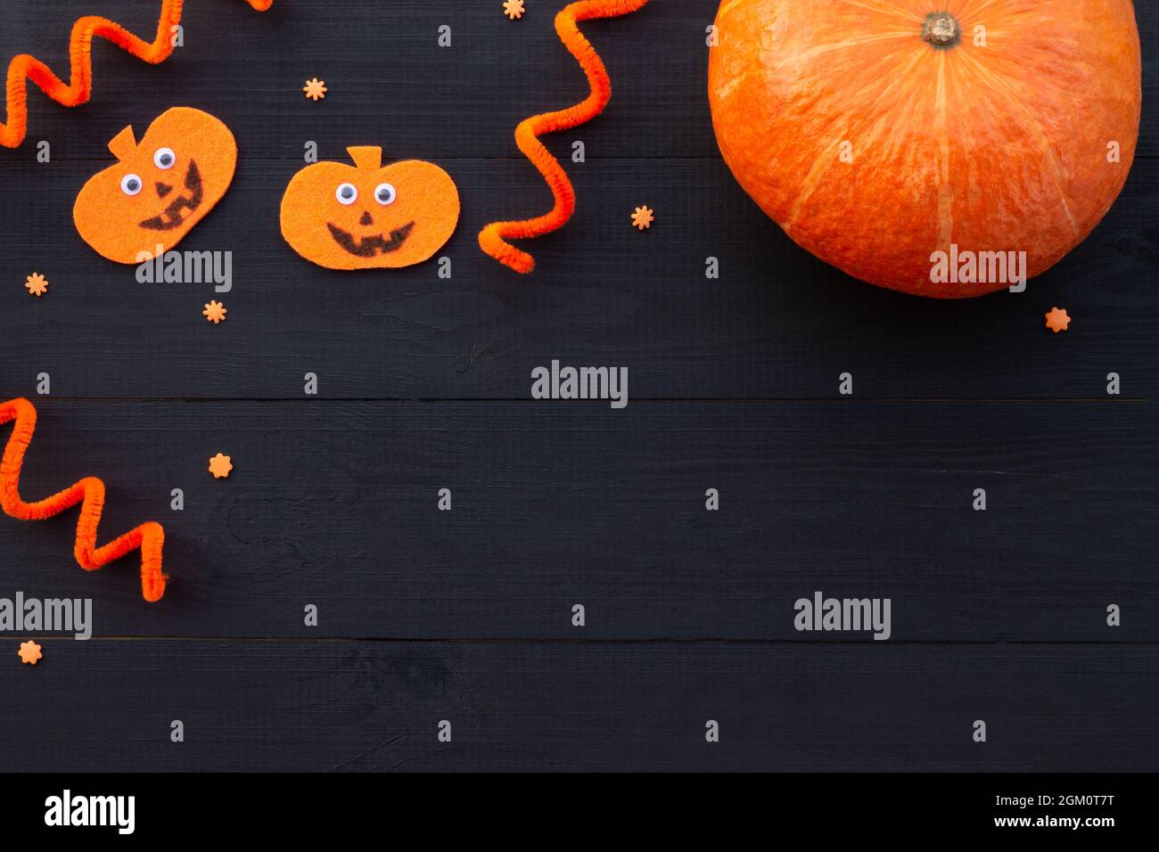 Orange and black Halloween flatlay. Pumpkins from felt and real pumpkin ...