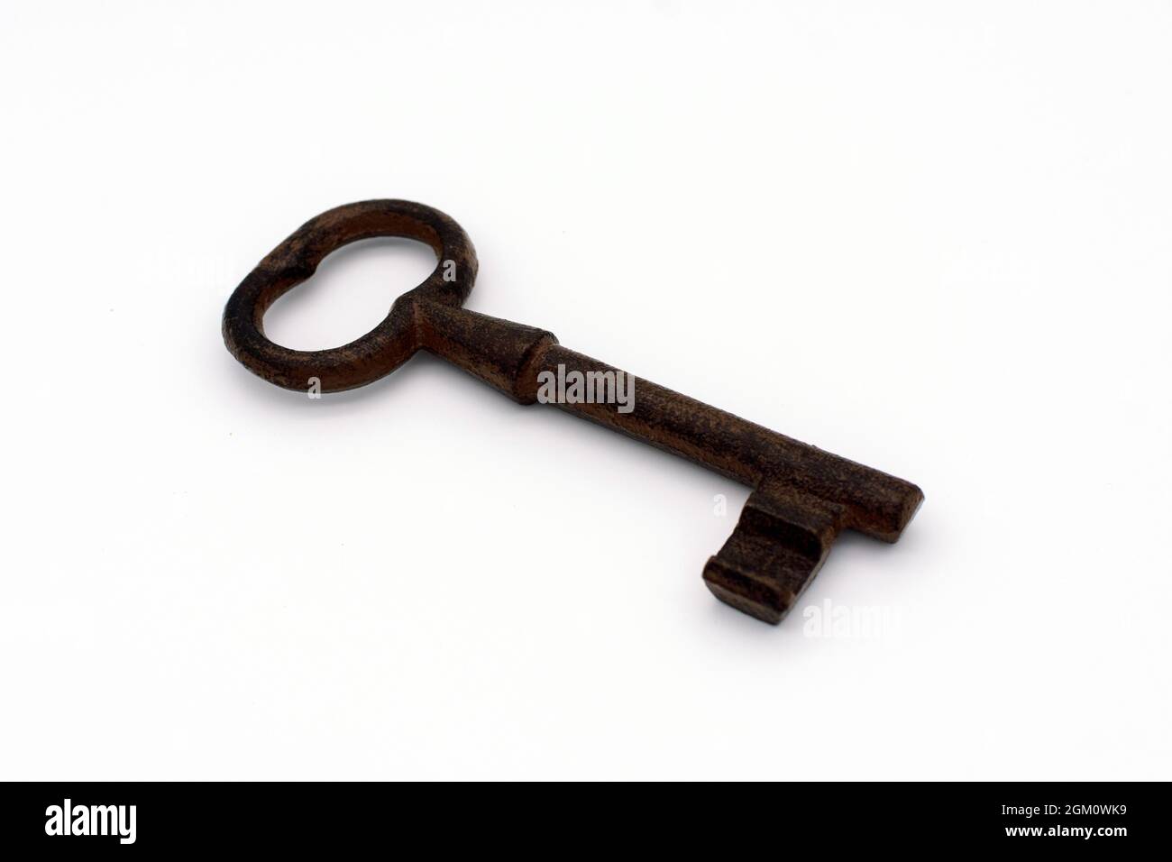 Old iron rusty key on white background. Selective focus. Close up. Stock Photo