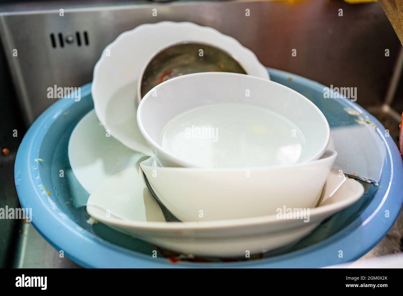 Used dishes prepared to wash on the kitchen sink Stock Photo