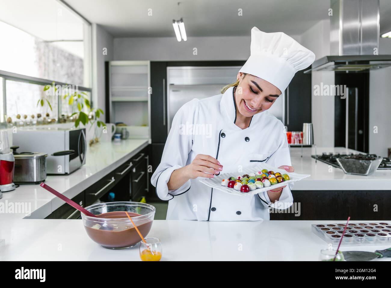 young latin woman chocolatier in chef hat with mexican chocolates