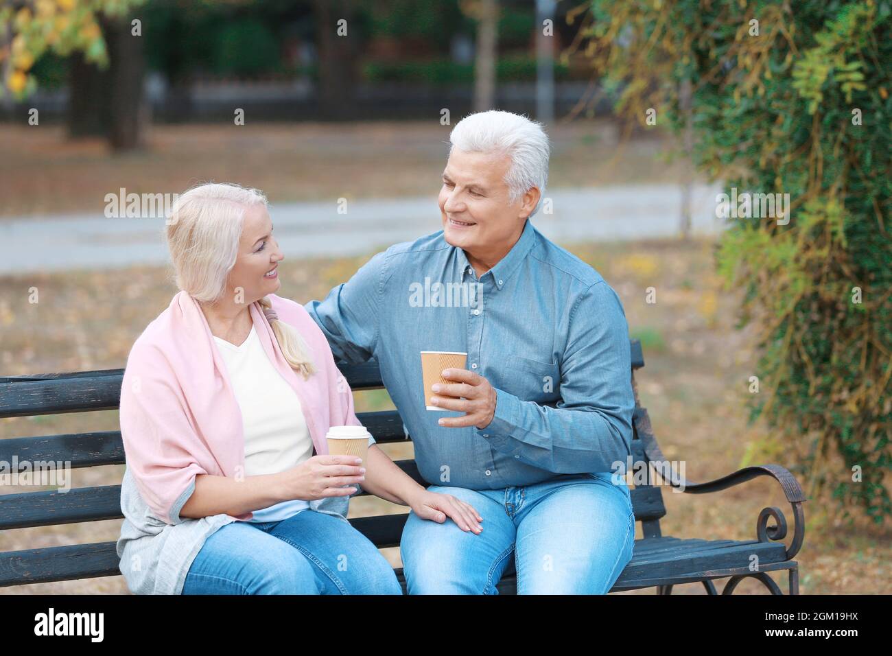 Mature couple sitting on bench outdoors Stock Photo - Alamy