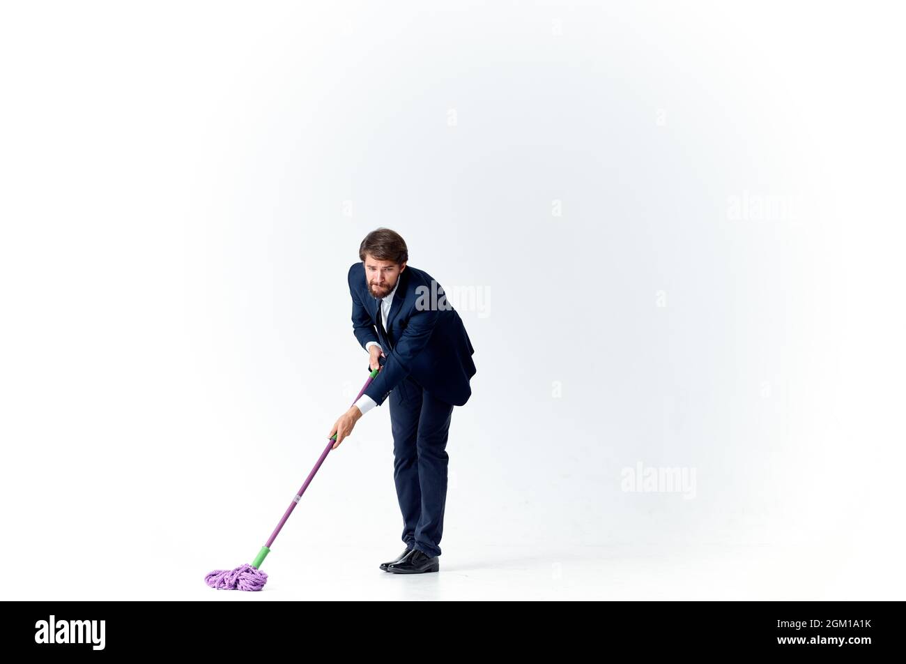 business man in a suit washes the floors with a mop cleaning Stock Photo