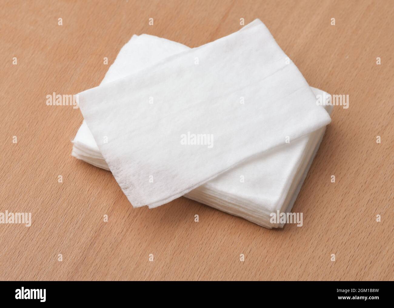 Closeup of unwrapped wet wipes stack on wooden table Stock Photo
