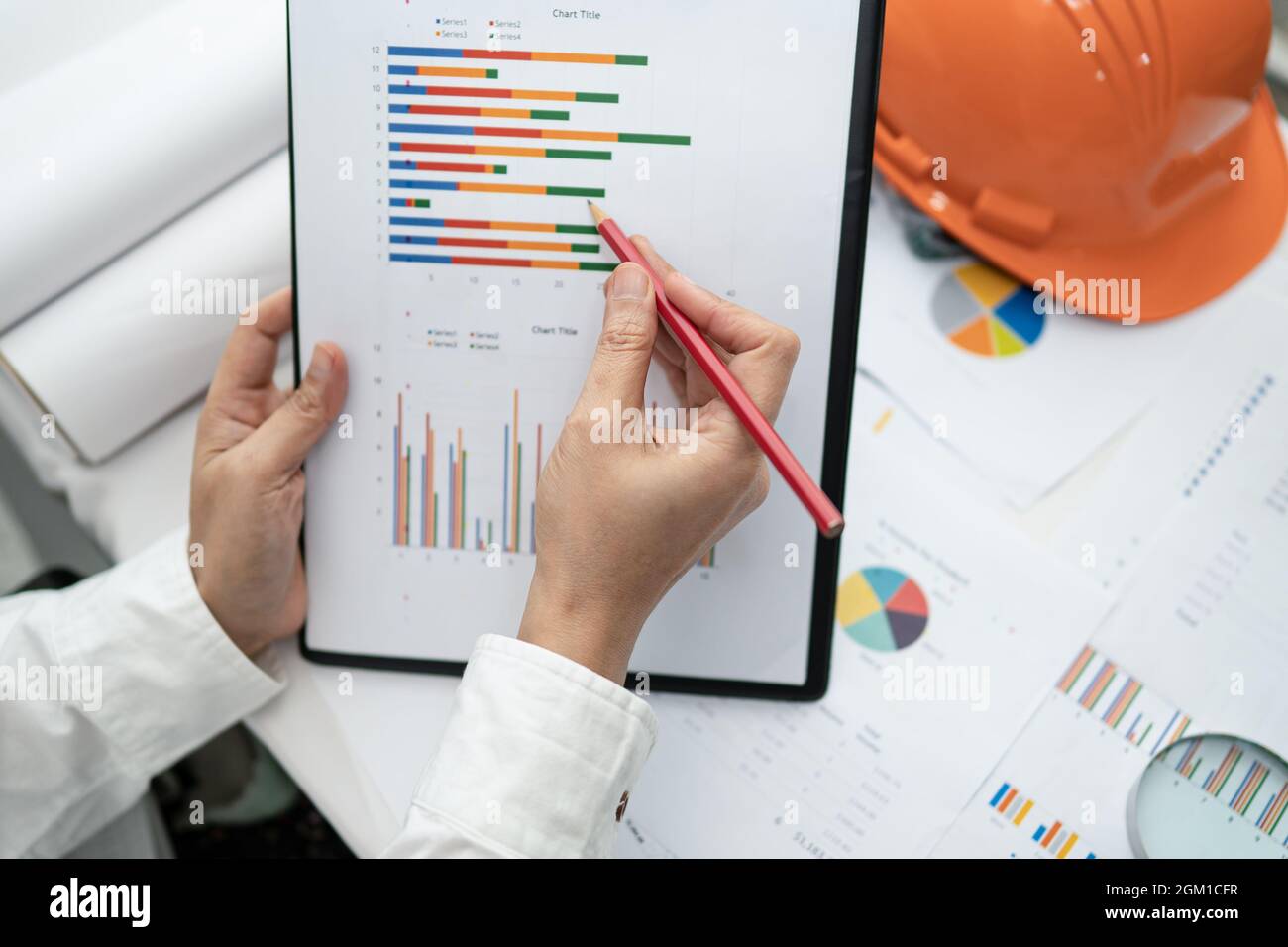 Engineer working project accounting with graph and construction helmet ...