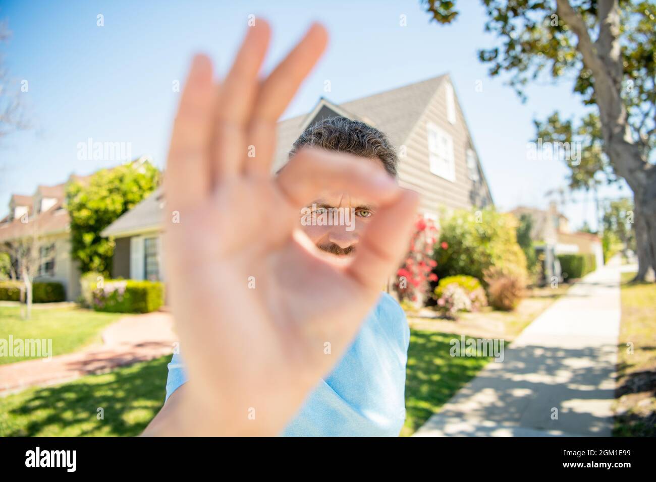ok gesture. real estate agent at house for sale. realtor welcoming visitors. Stock Photo